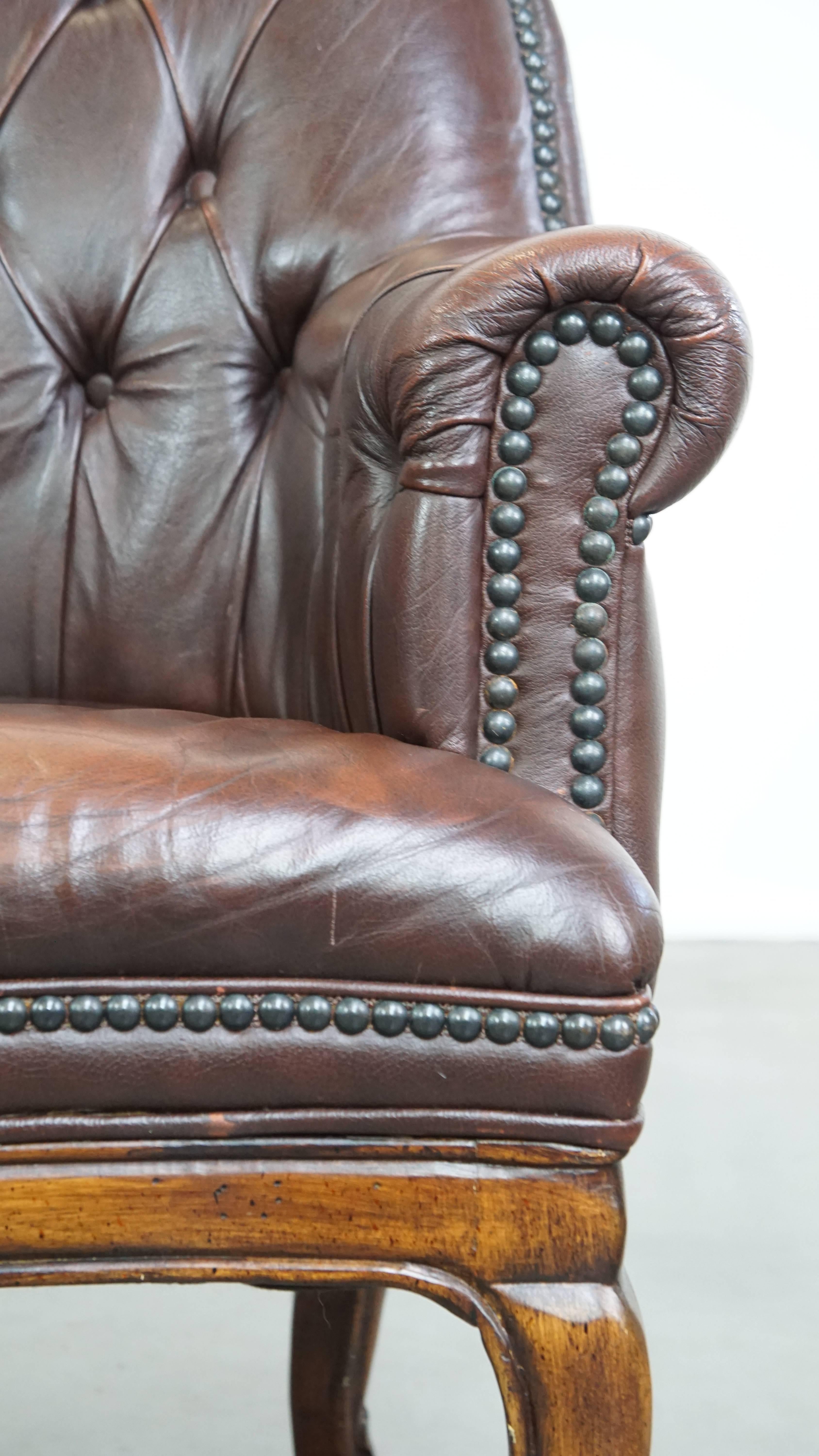 Charming, classic cow leather English chesterfield armchair with elegant legs For Sale 6