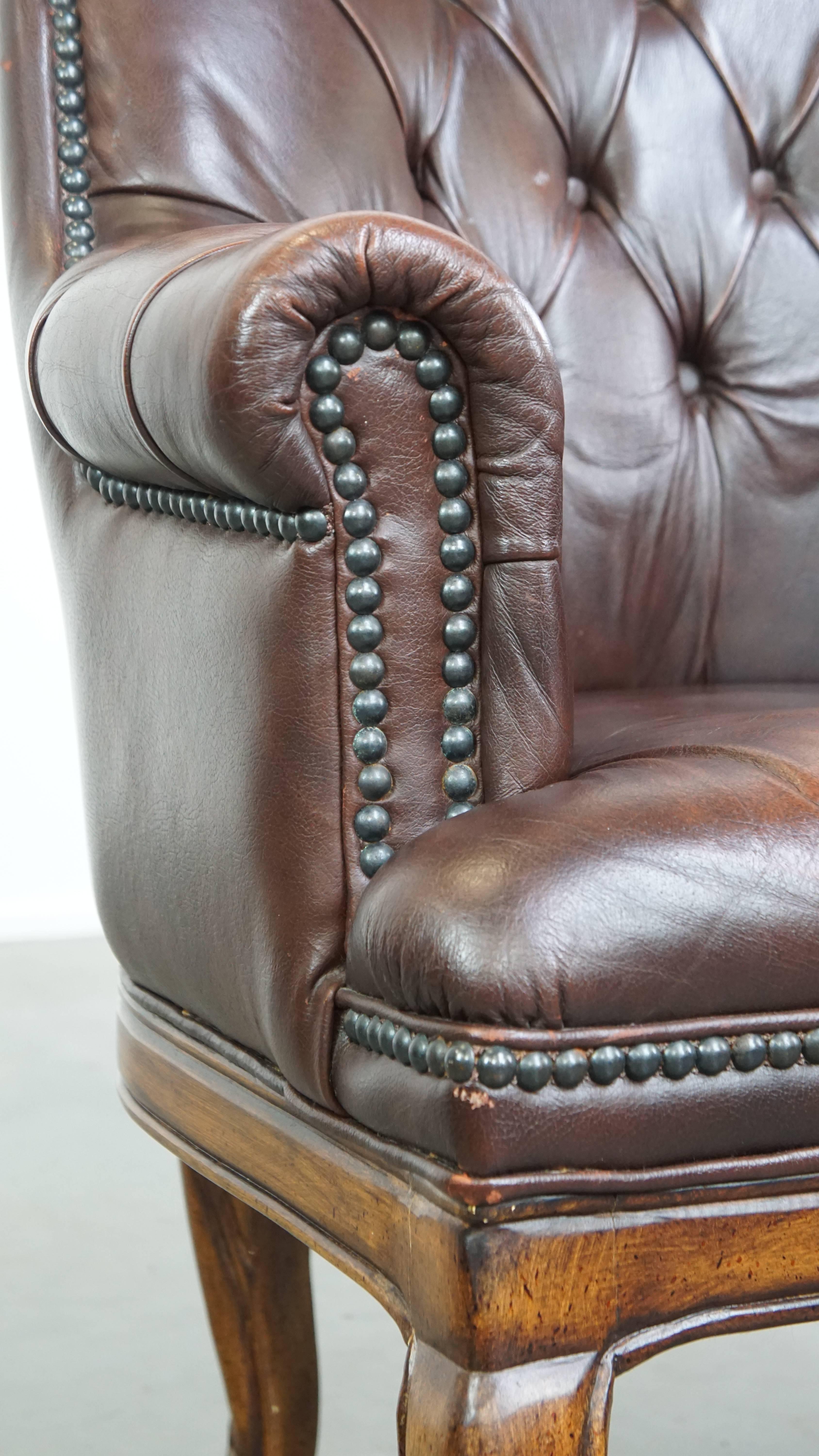 Charming, classic cow leather English chesterfield armchair with elegant legs For Sale 7
