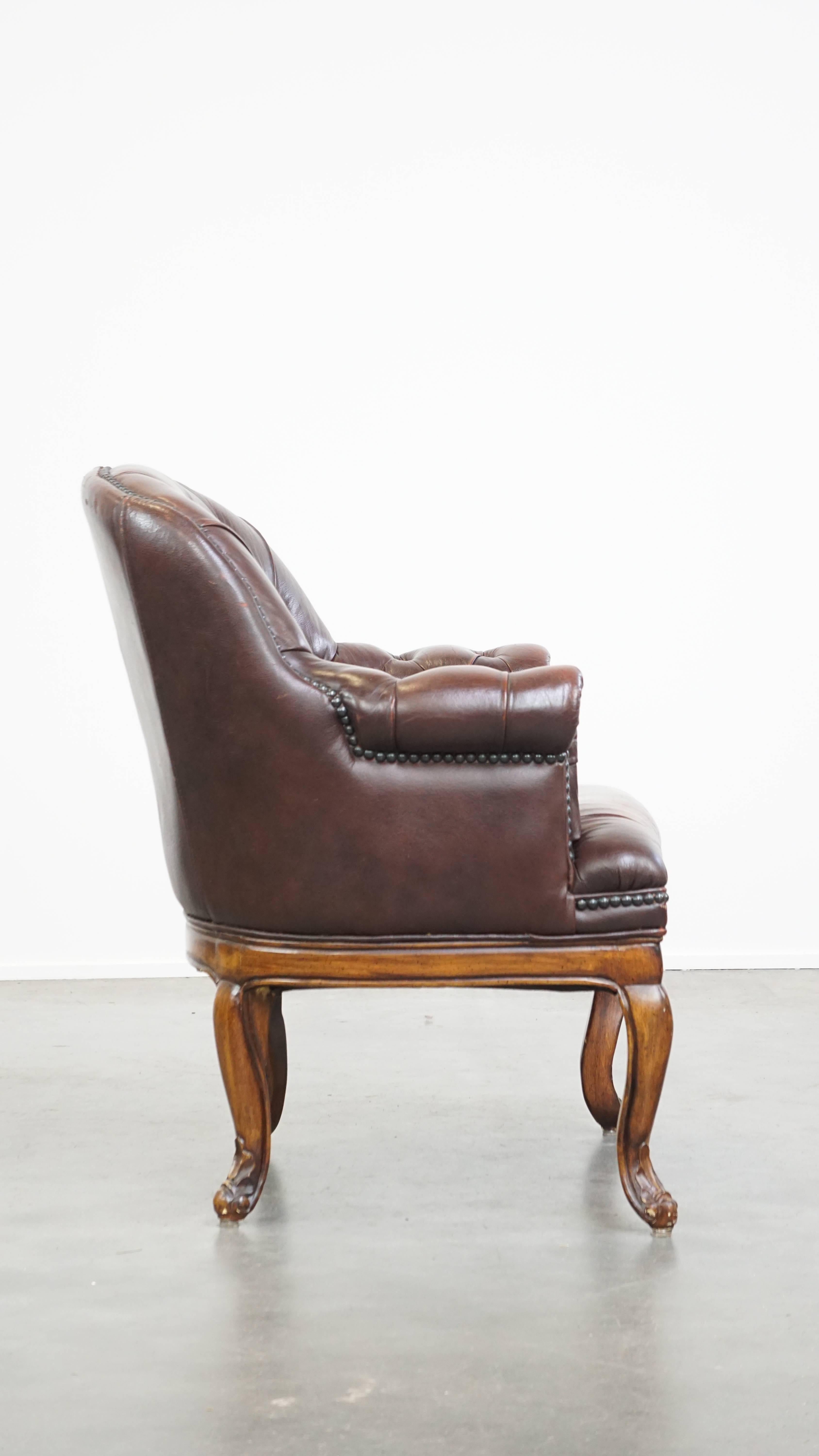 Chesterfield Charming, classic cow leather English chesterfield armchair with elegant legs For Sale