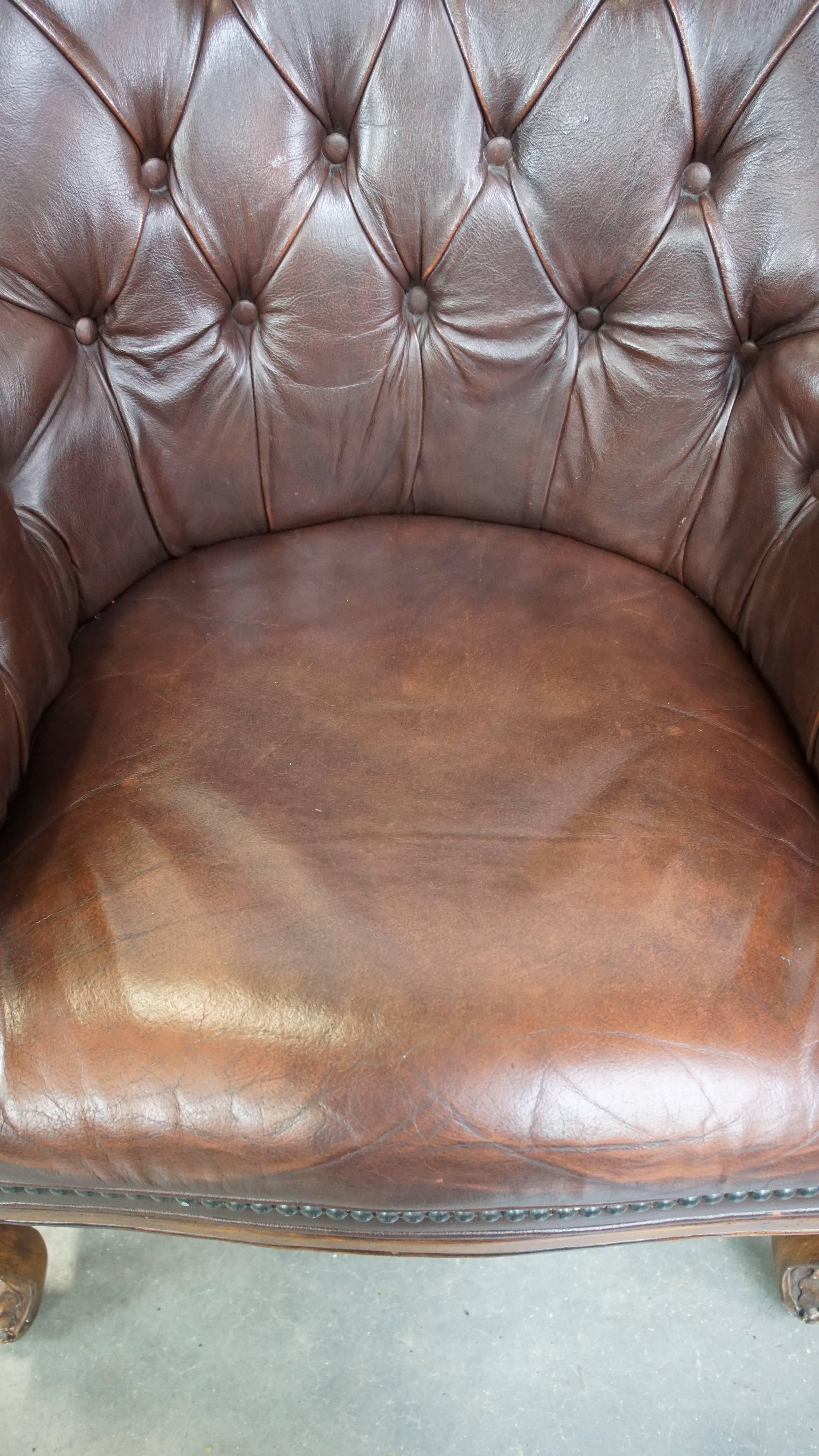 20th Century Charming, classic cow leather English chesterfield armchair with elegant legs For Sale
