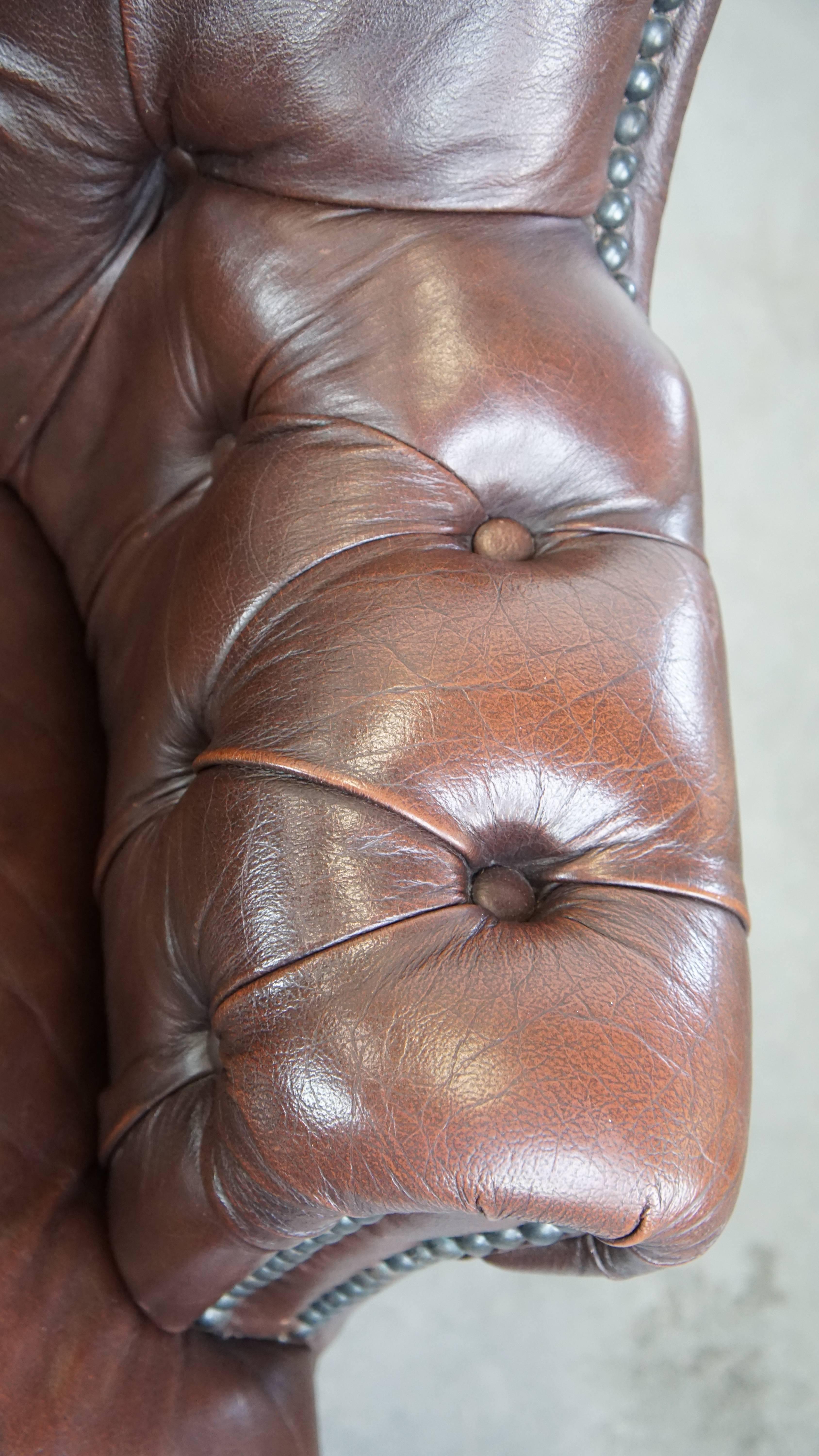 Charming, classic cow leather English chesterfield armchair with elegant legs For Sale 1