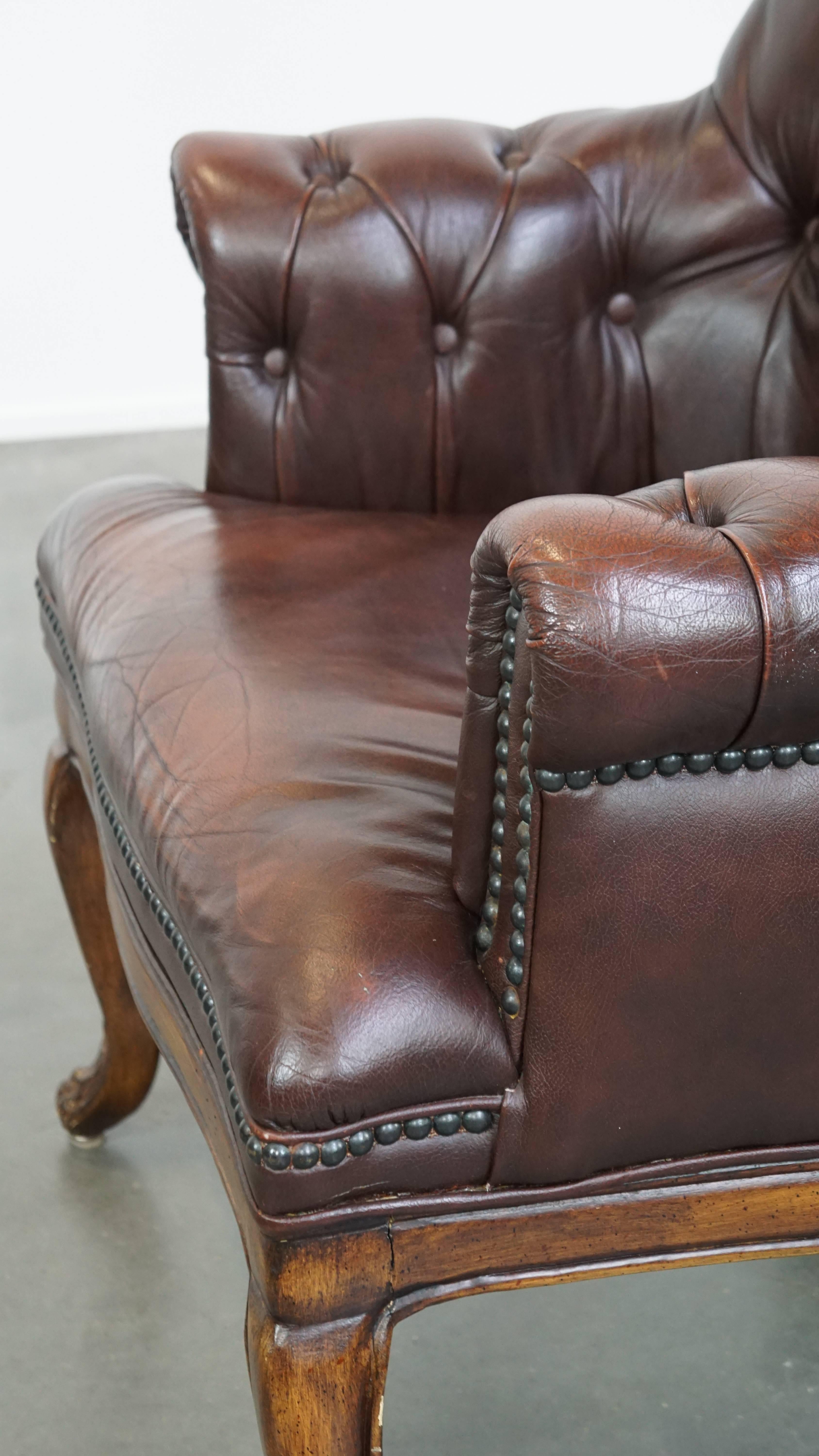 Charming, classic cow leather English chesterfield armchair with elegant legs For Sale 2