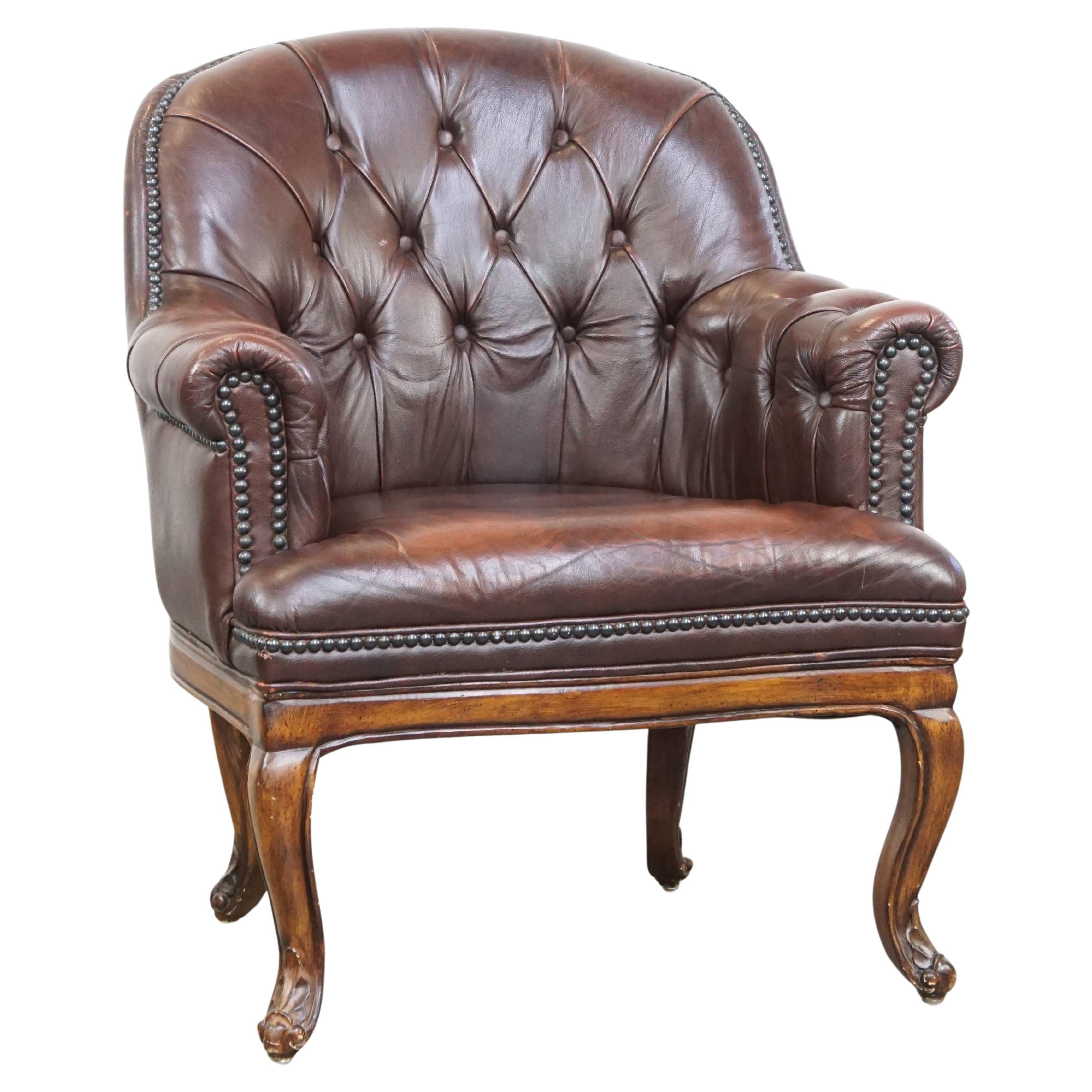 Charming, classic cow leather English chesterfield armchair with elegant legs