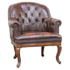 Charming, classic cow leather English chesterfield armchair with elegant legs