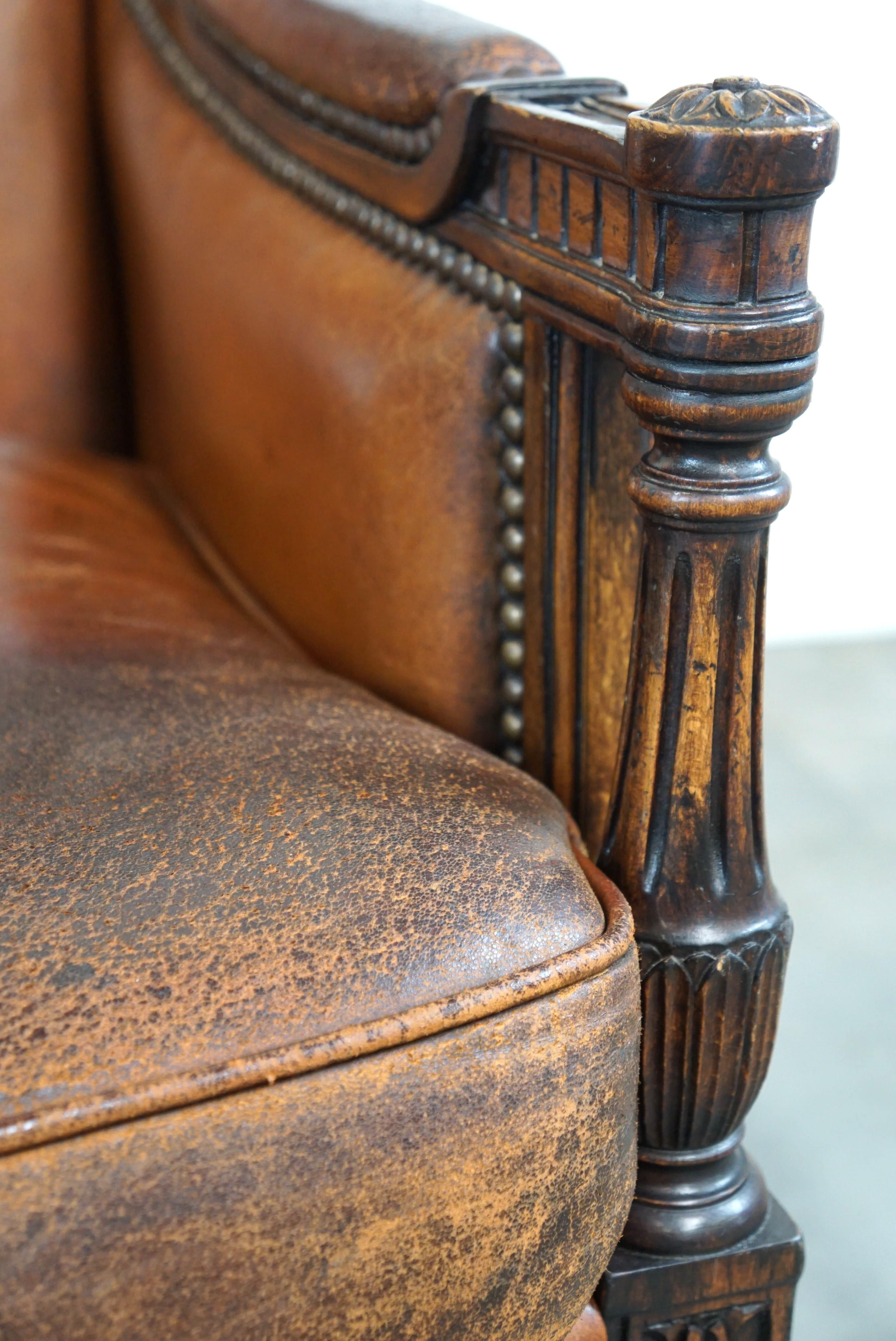 Charmant fauteuil classique en cuir de mouton avec sculptures en bois et belle patine. en vente 3