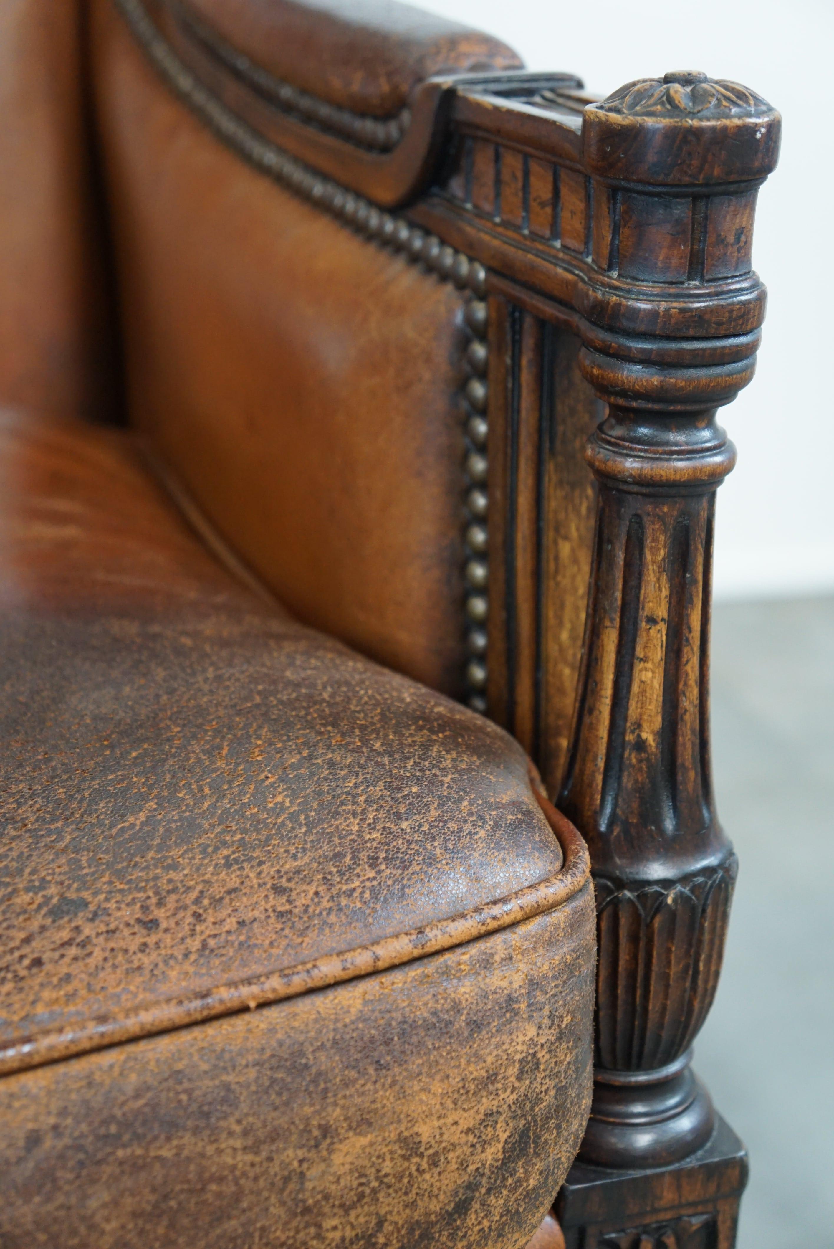 Charming classic sheep leather armchair with wood carving and a nice patina For Sale 4