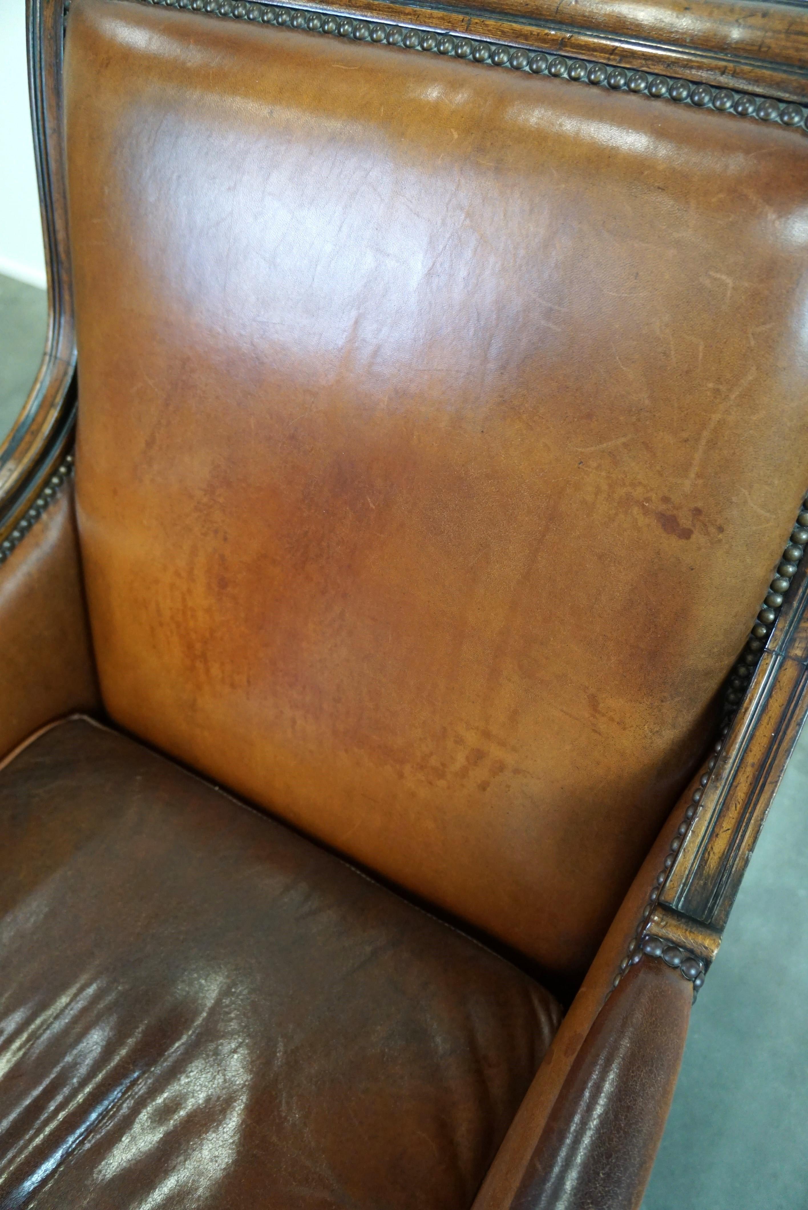 Charmant fauteuil classique en cuir de mouton avec sculptures en bois et belle patine. en vente 4