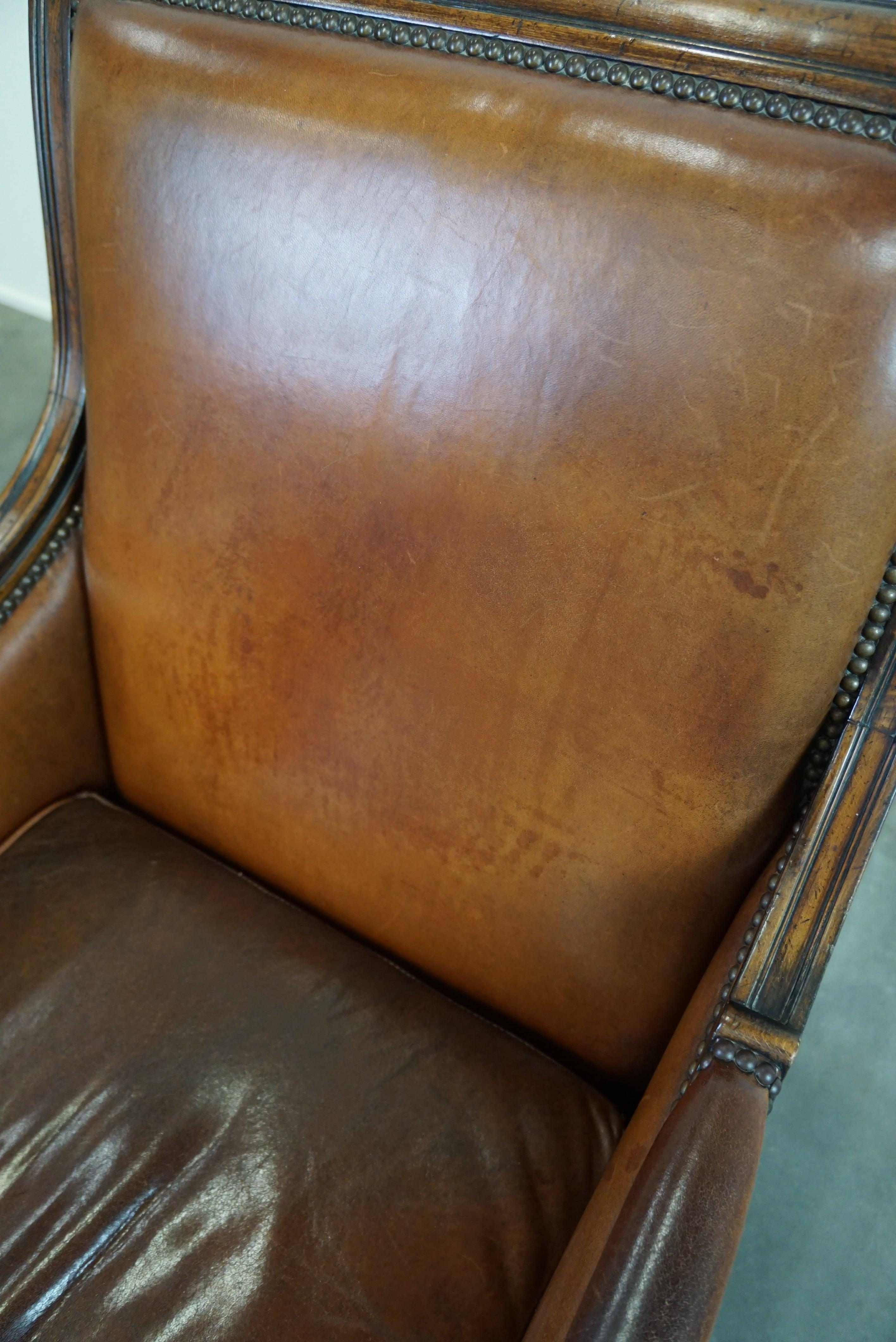 Charming classic sheep leather armchair with wood carving and a nice patina For Sale 8