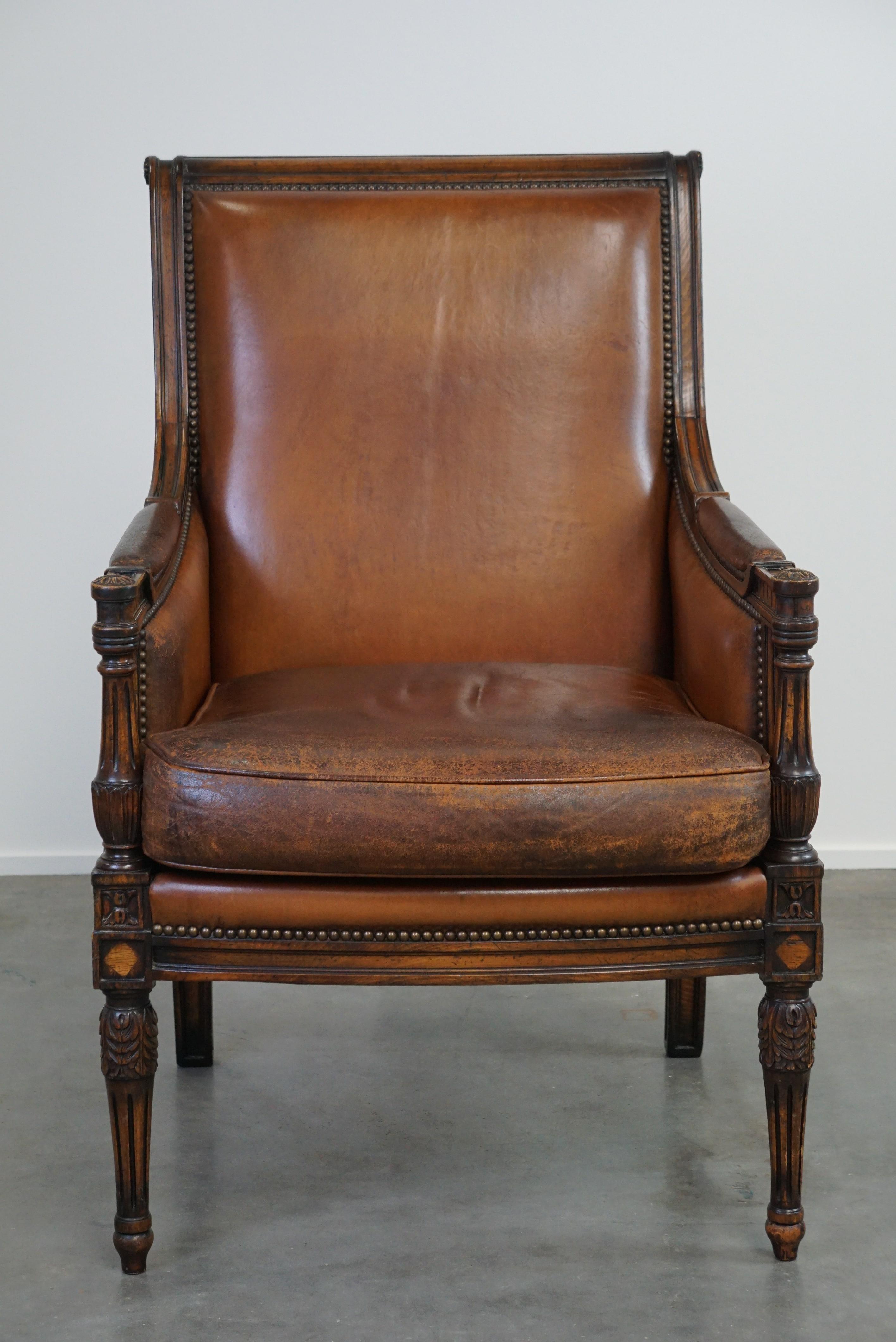 Dutch Charming classic sheep leather armchair with wood carving and a nice patina For Sale