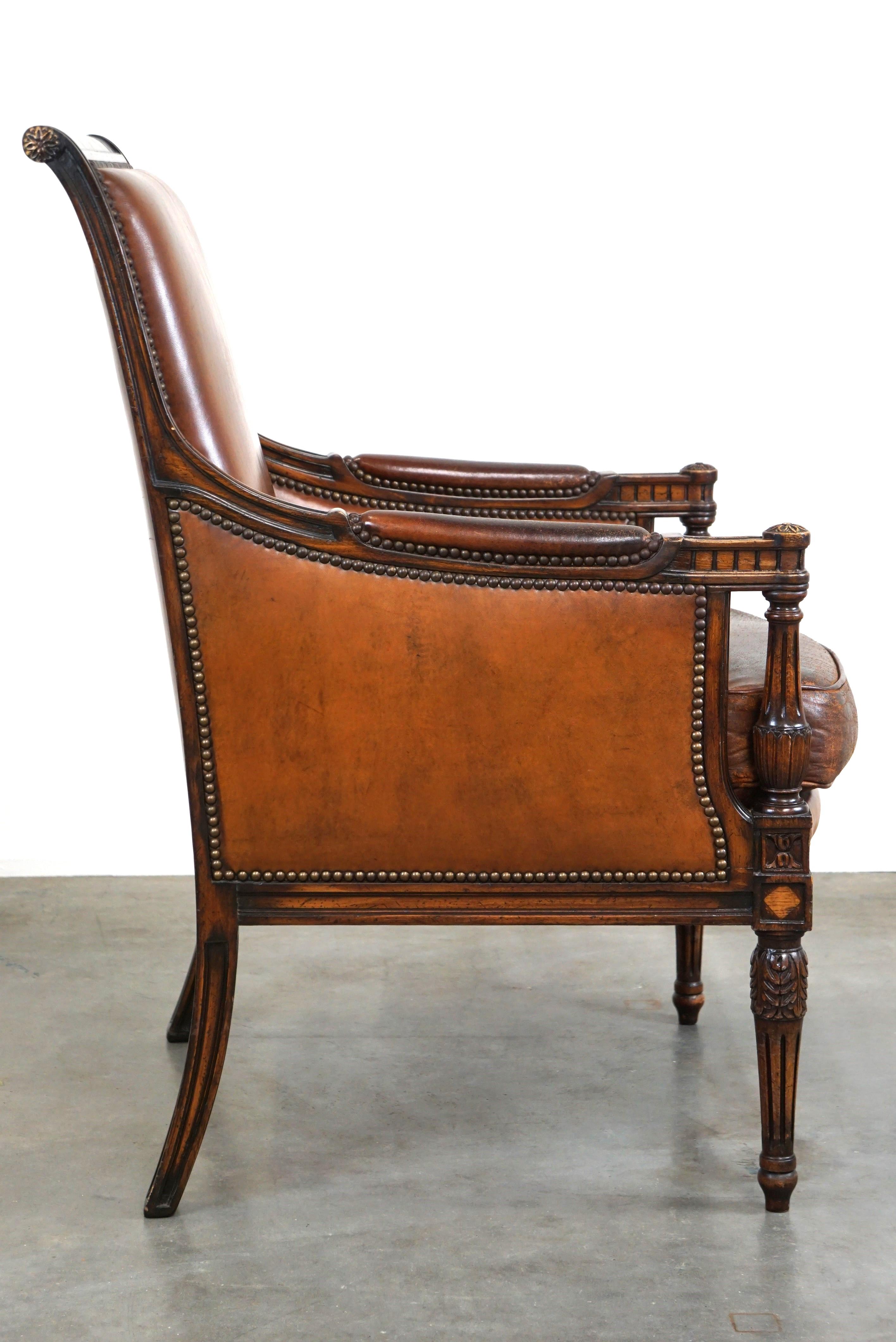 Néerlandais Charmant fauteuil classique en cuir de mouton avec sculptures en bois et belle patine. en vente