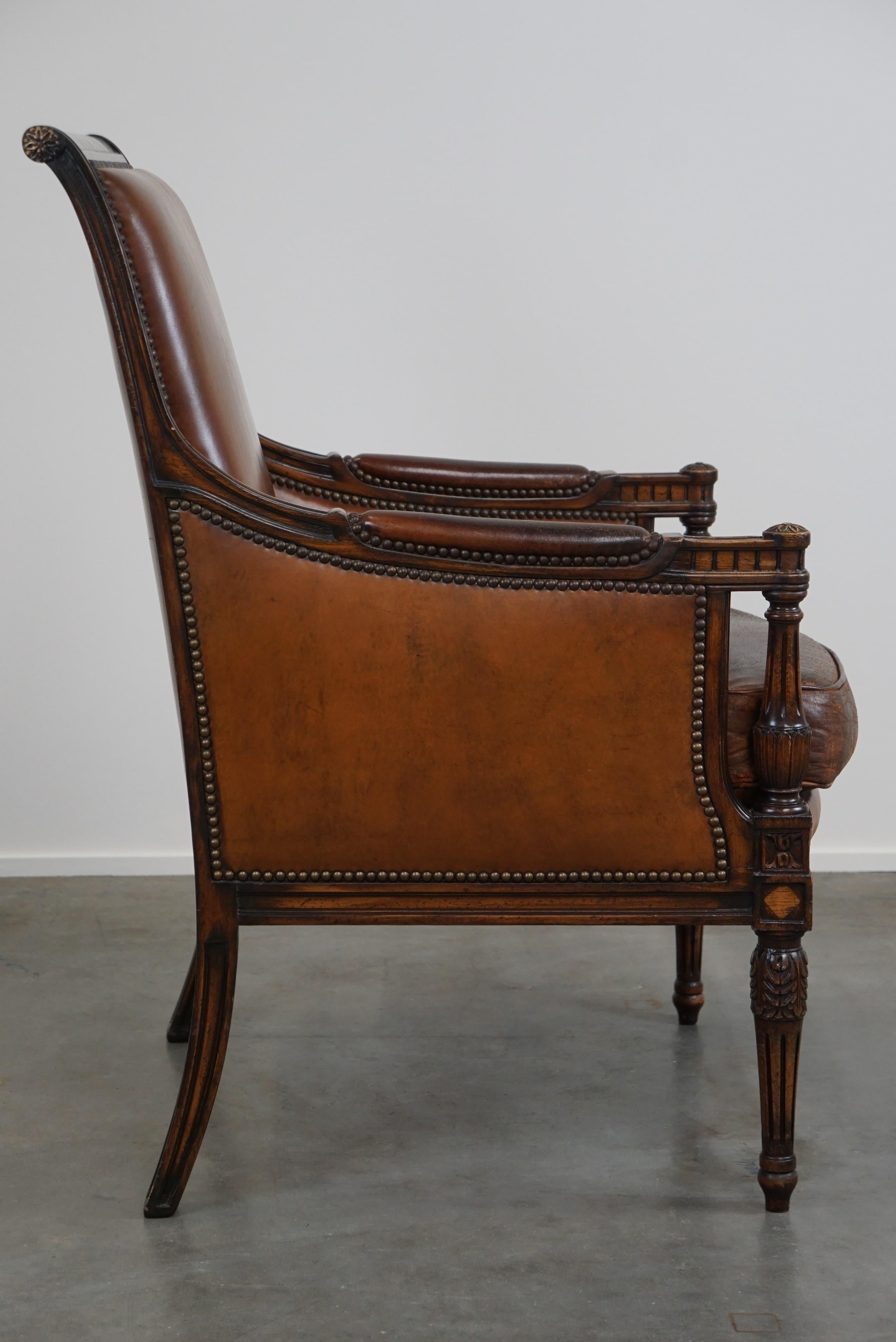 Hand-Crafted Charming classic sheep leather armchair with wood carving and a nice patina For Sale