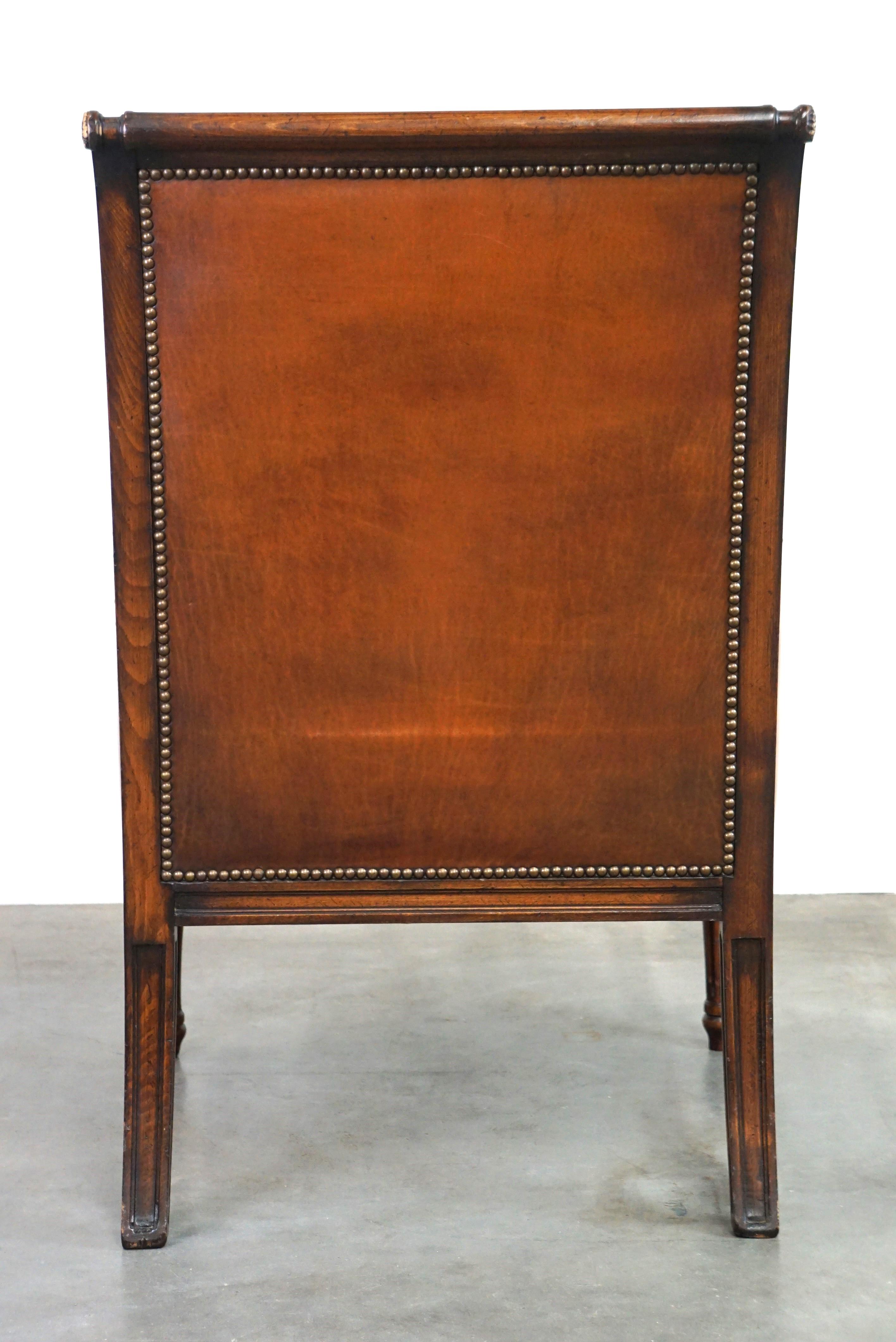 Fait main Charmant fauteuil classique en cuir de mouton avec sculptures en bois et belle patine. en vente