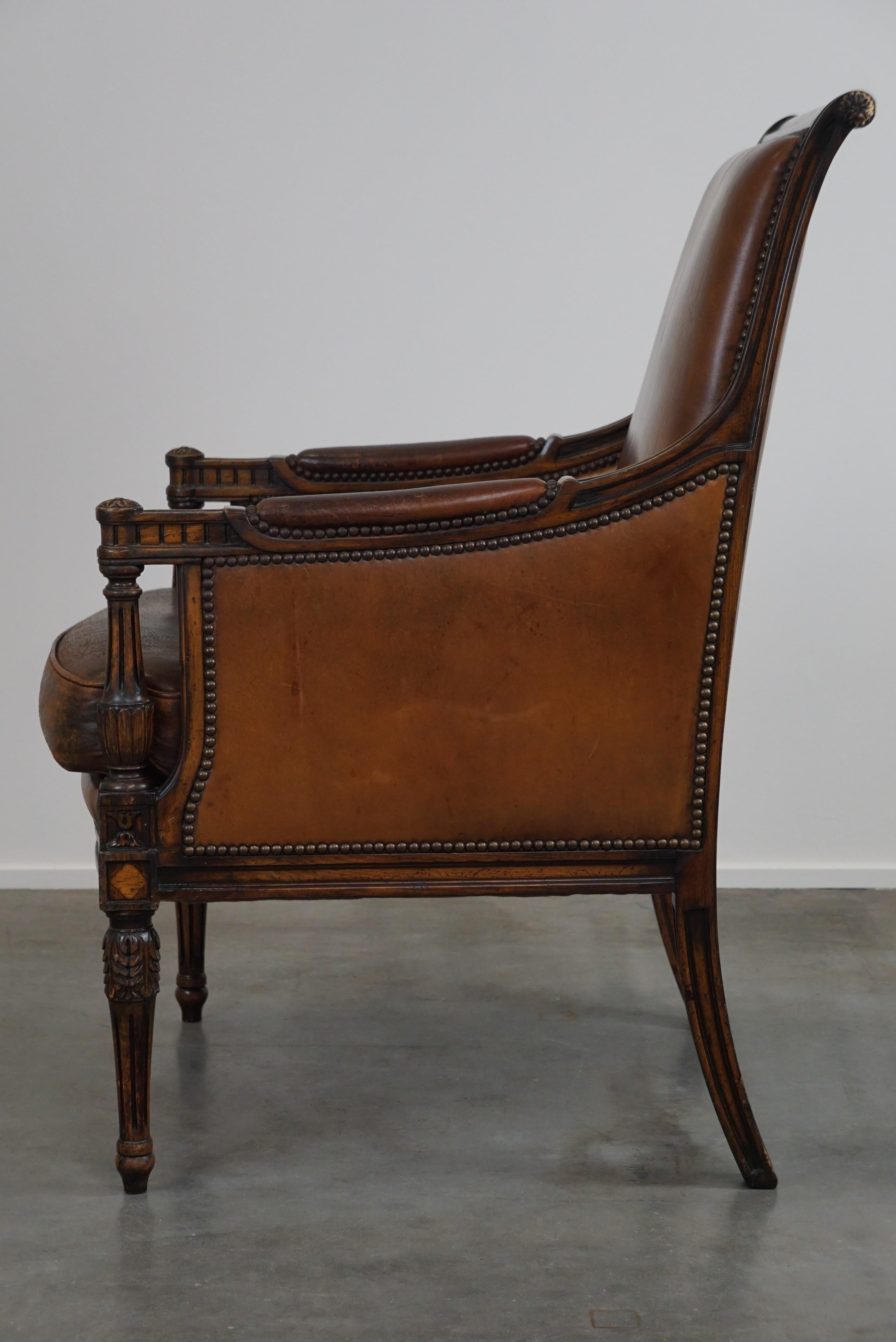 Contemporary Charming classic sheep leather armchair with wood carving and a nice patina For Sale