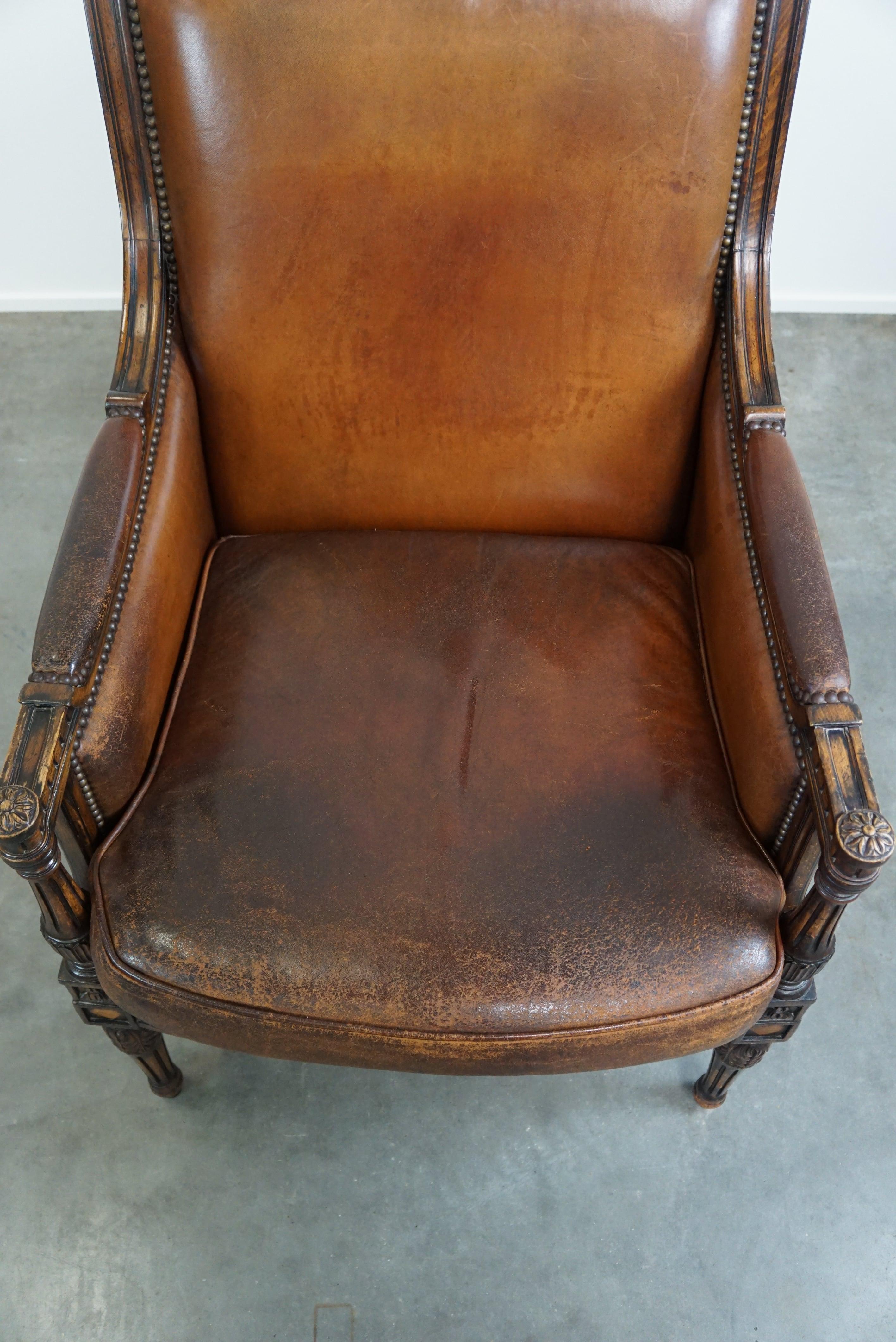 Leather Charming classic sheep leather armchair with wood carving and a nice patina For Sale