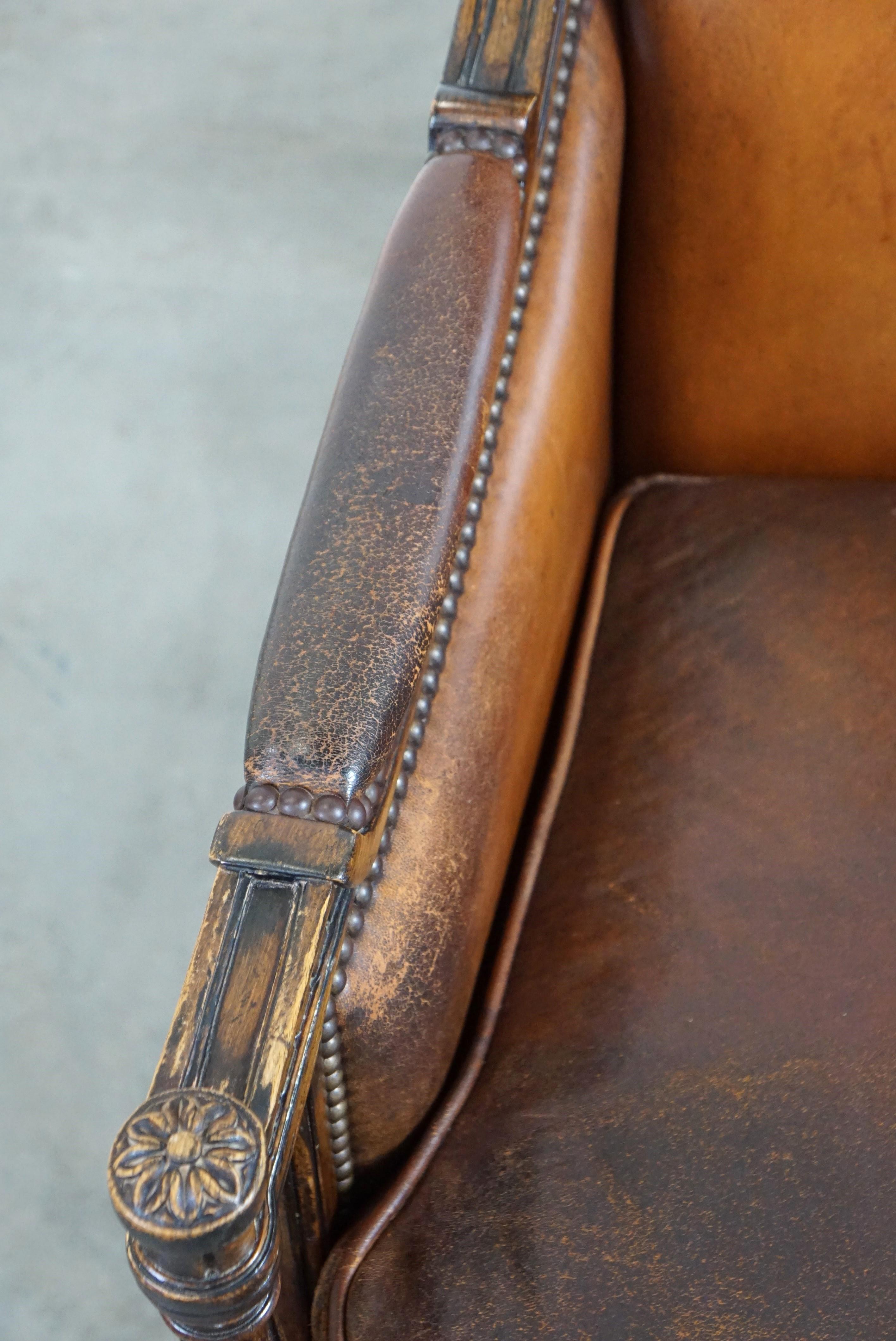 Cuir Charmant fauteuil classique en cuir de mouton avec sculptures en bois et belle patine. en vente