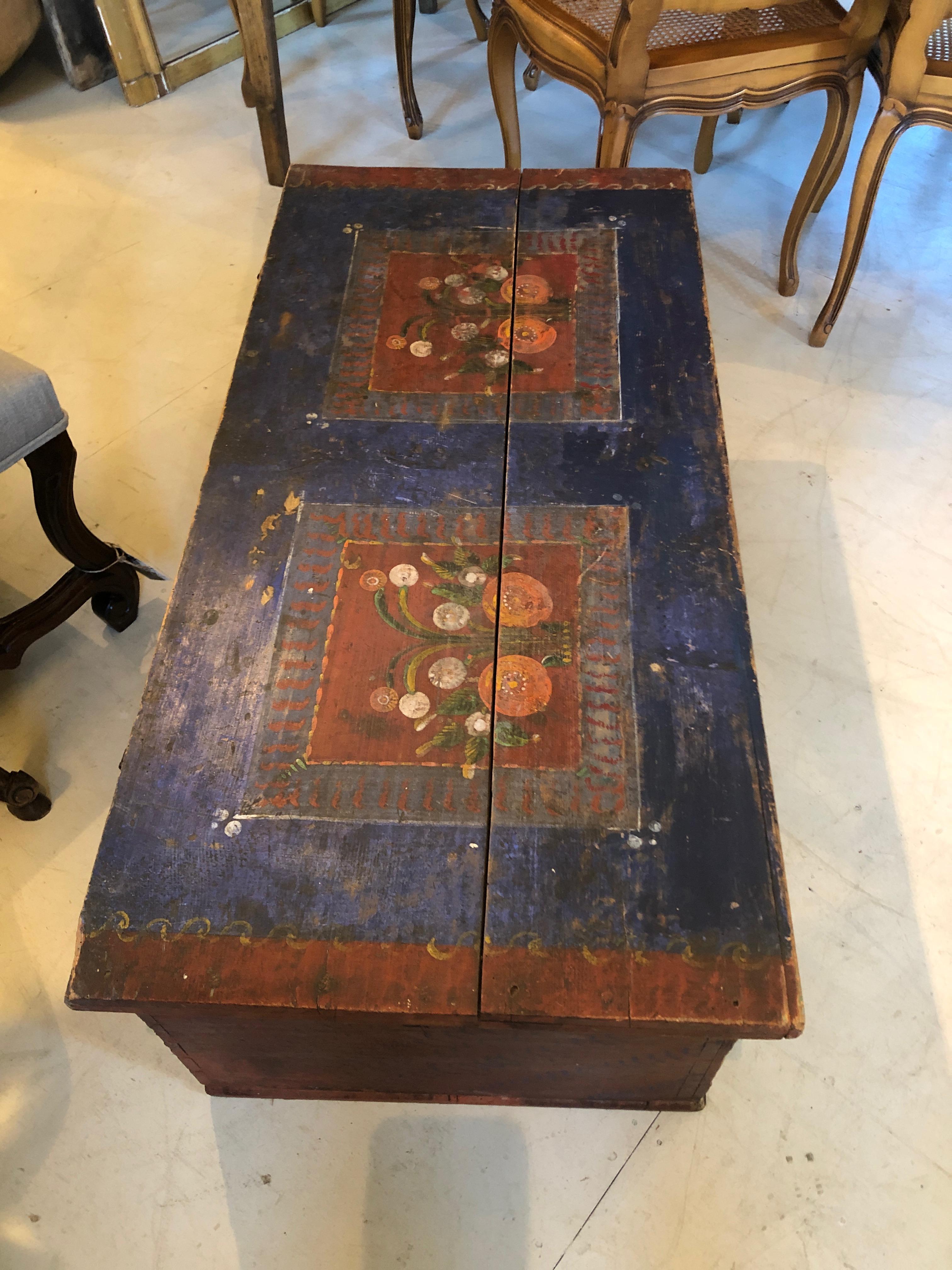 A charming hand painted folk art chest from Sweden, circa 1806, having a dark blue background and delightful mulit-colored renderings of flowers in planters with red, orange, green, and white.