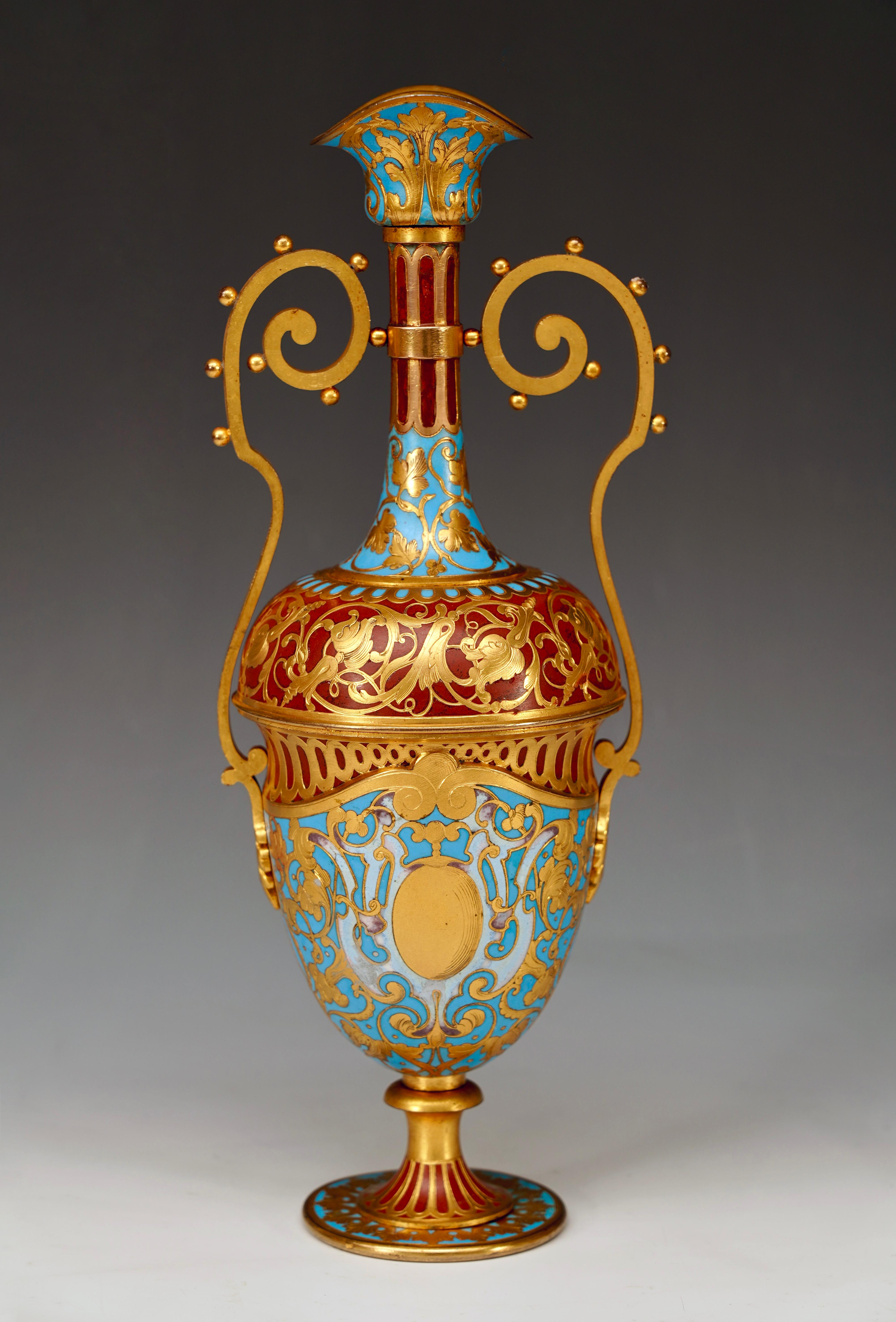 Signed F. Barbedienne & Cie

Height : 31,5 cm (12,4 in.) ; Width : 12 cm (4,7 in.) ; Depth : 10,5 cm (4,1 in.)

Charming baluster-shaped ewer in gilded bronze decorated with red and blue polychrome cloisonné enamel. Two beaded handles connect the