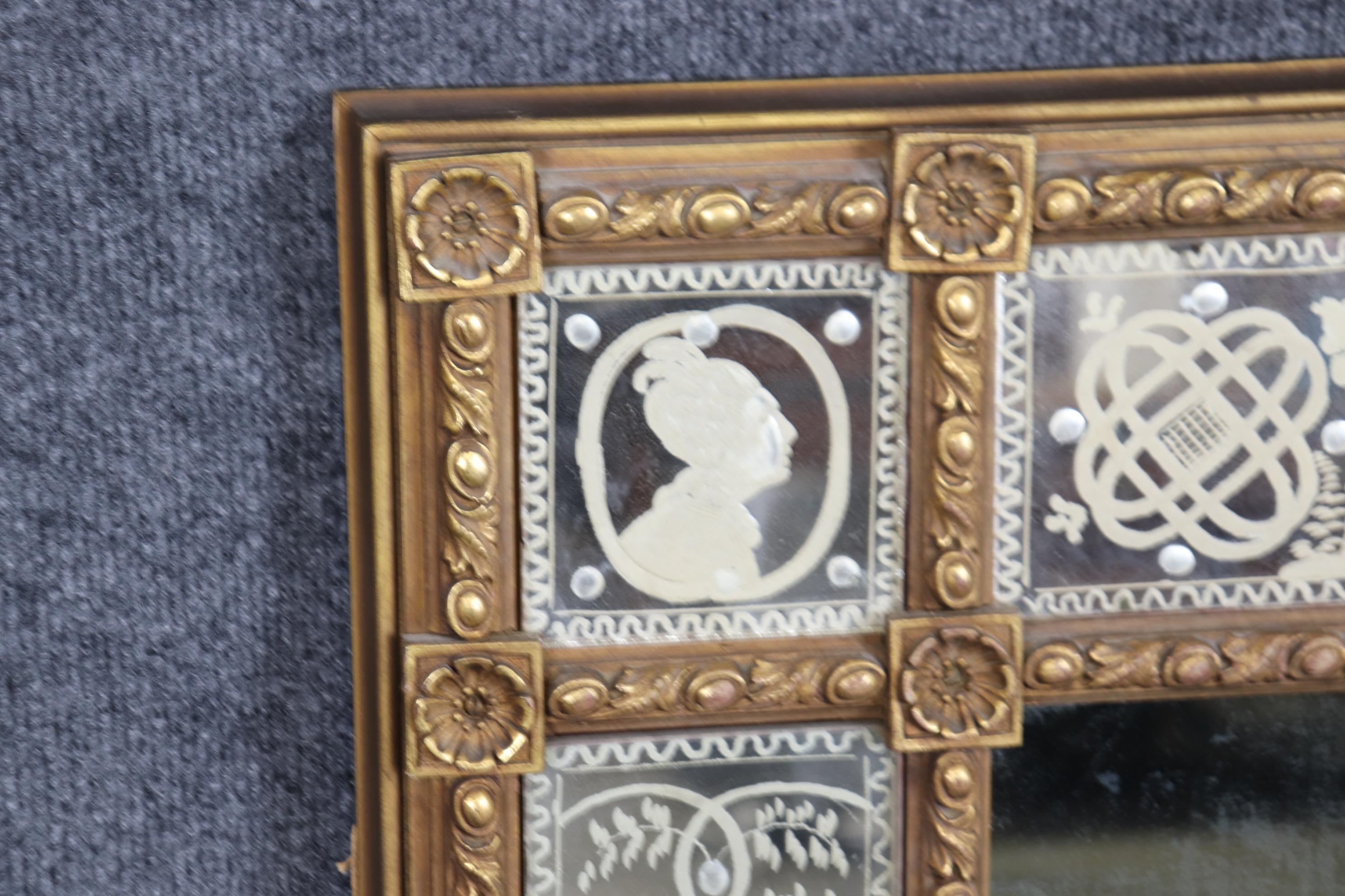 This is a charming etched glass mirror made in the Venetian style. The mirror features a man and his wife in different portraitures in a beautiful gold gilt carved frame. The mirror is clouded and has a definite patina and is not crystal clear.