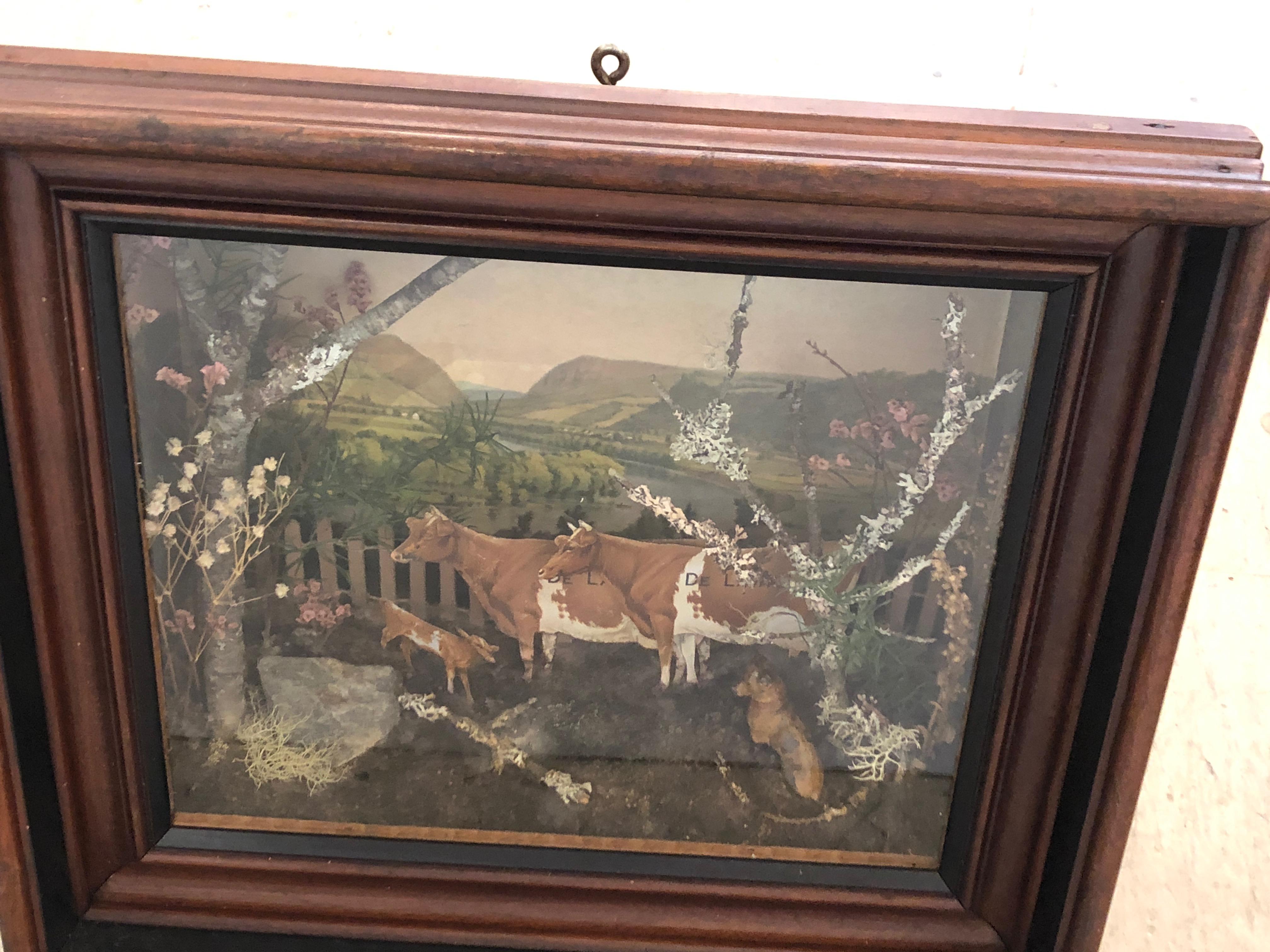 A charming Folk Art shadow box diorama having a bucolic pastural scene inside including cows and the French countryside.