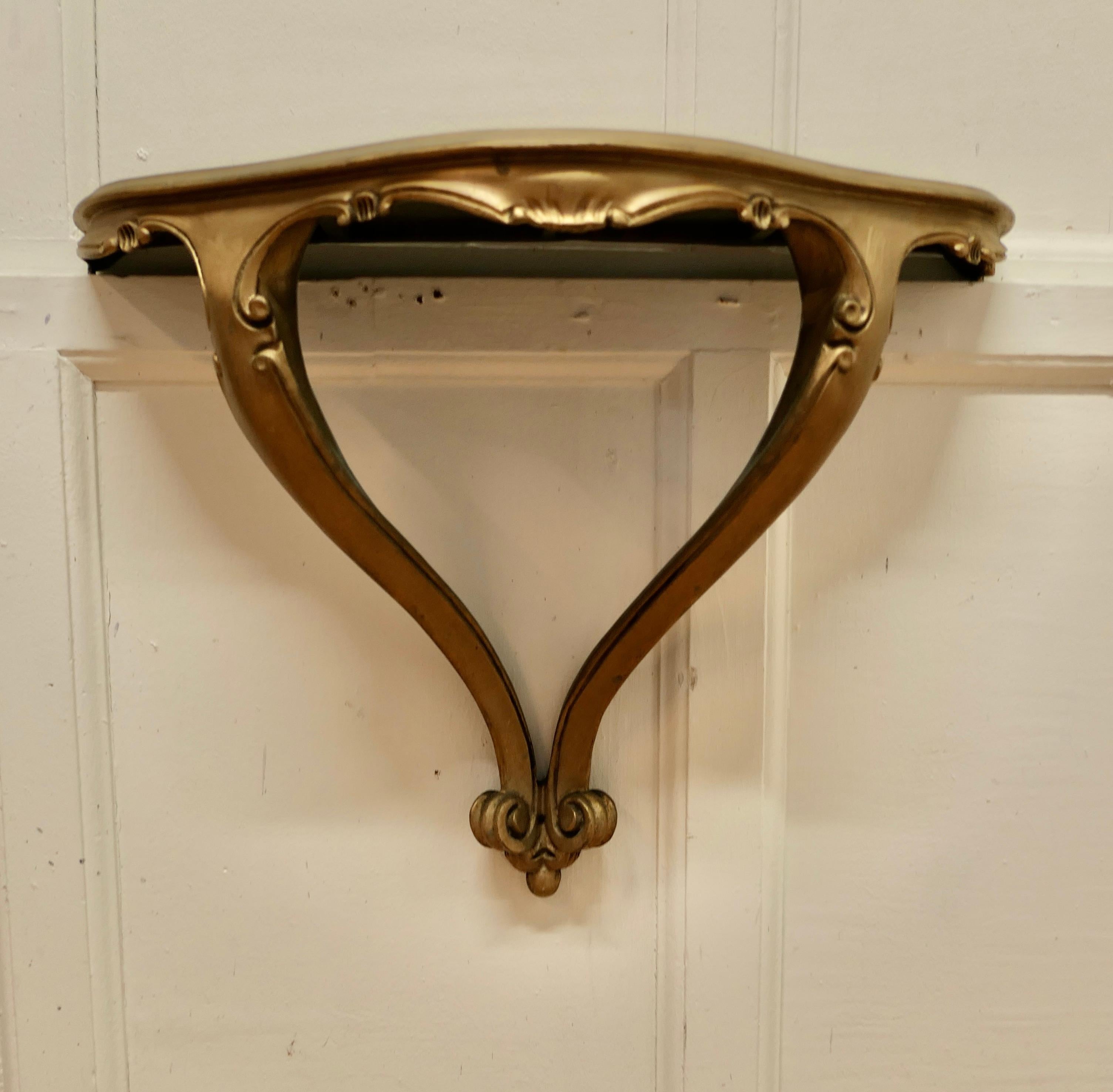 Charming, French carved gilt console wall shelf.

A beautifully carved little gilt shelf, it has a serpentine shaped top and a double wall fixing leg
This is a delicate little piece and the Gold has darkened with age 
The shelf is in good