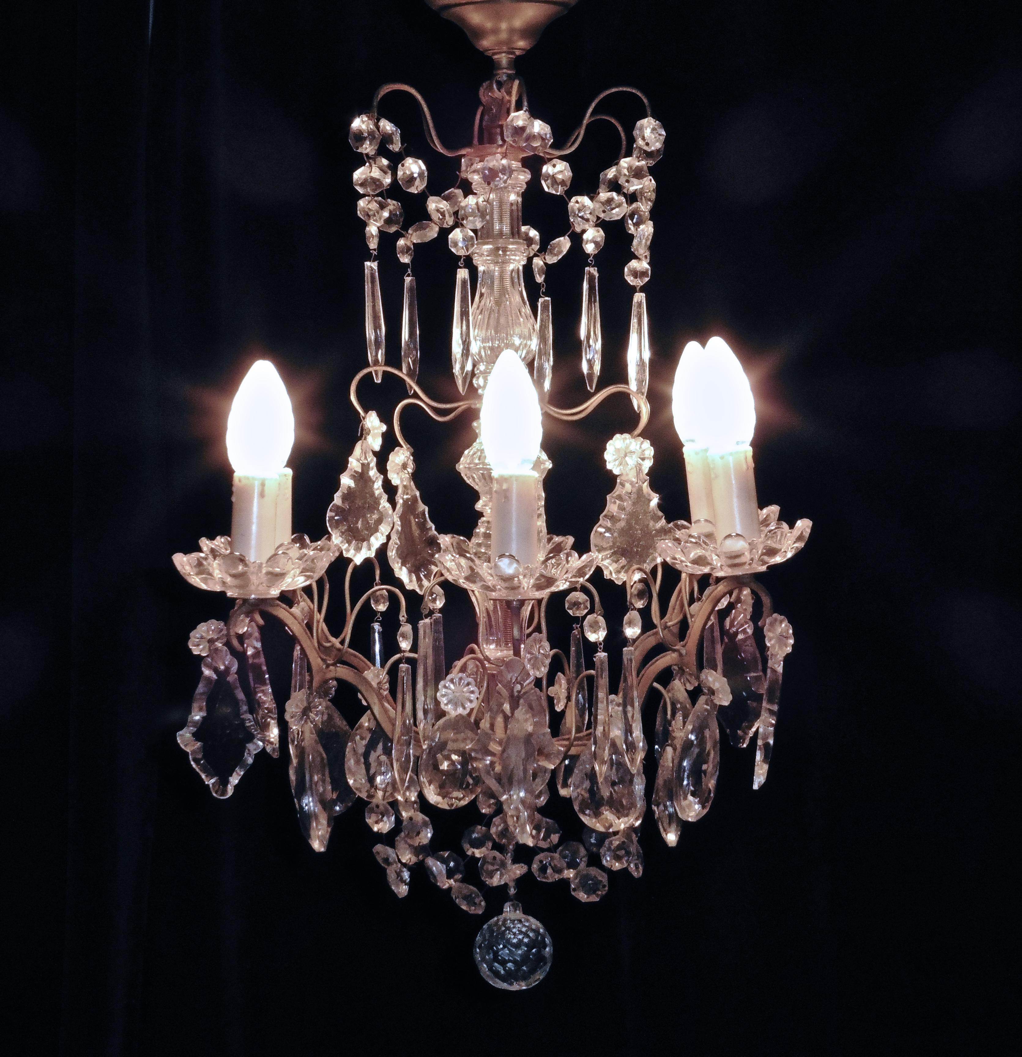 A charming French cut glass 6 branch brass chandelier.

This is a superb brass chandelier, the brass has a gilded finish and the 6 arms have pressed glass sconces which are hung with glass chains, drops and pendants, in a variety of pretty shapes