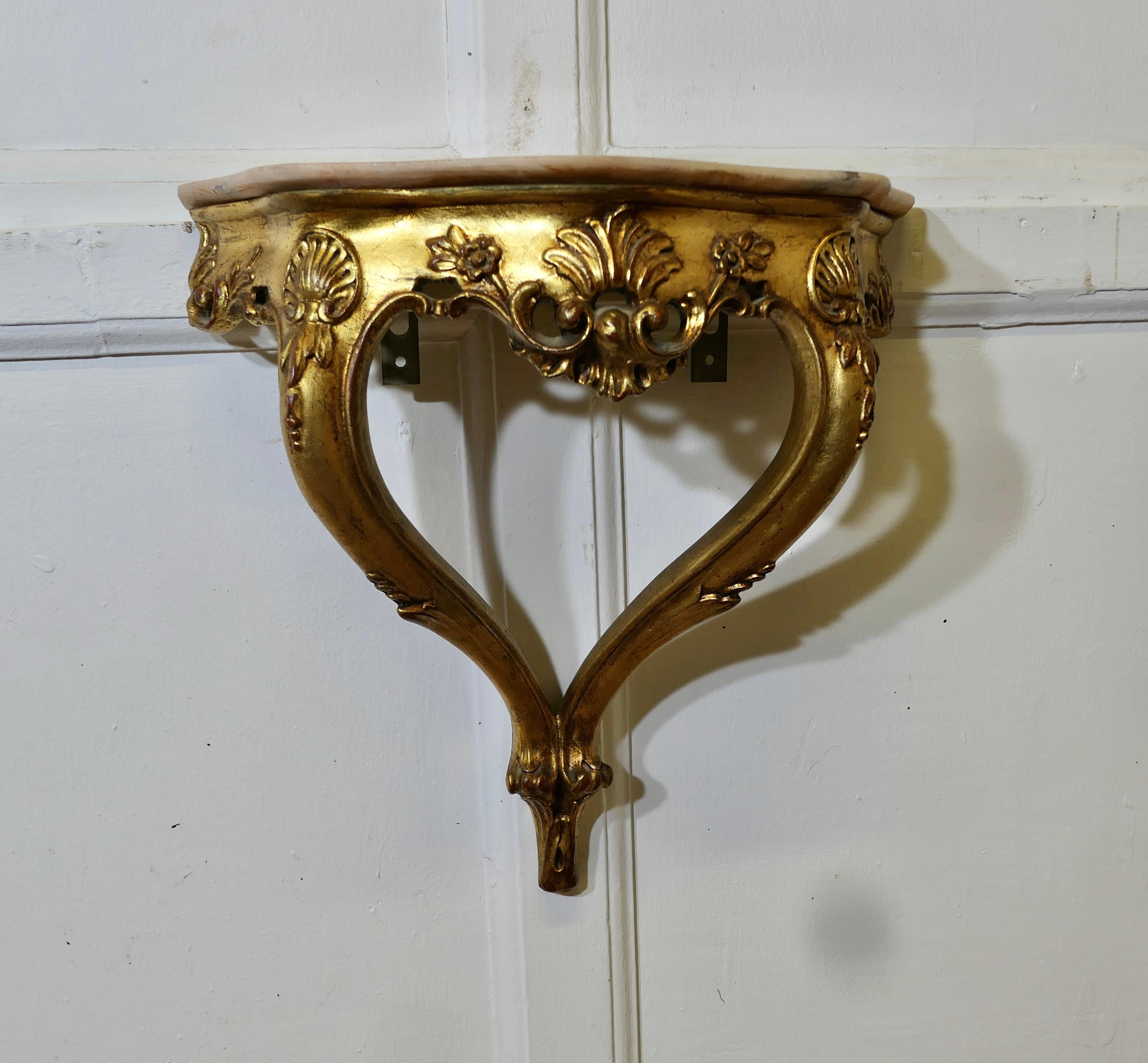 Charming French Gilt and Marble Console Hall Table, Wall Shelf

A beautiful gilt console table or shelf with a shaped pale pink Marble top

This is a delicate little piece, it fixes to the wall by means of brackets screwed to the wall , these cannot