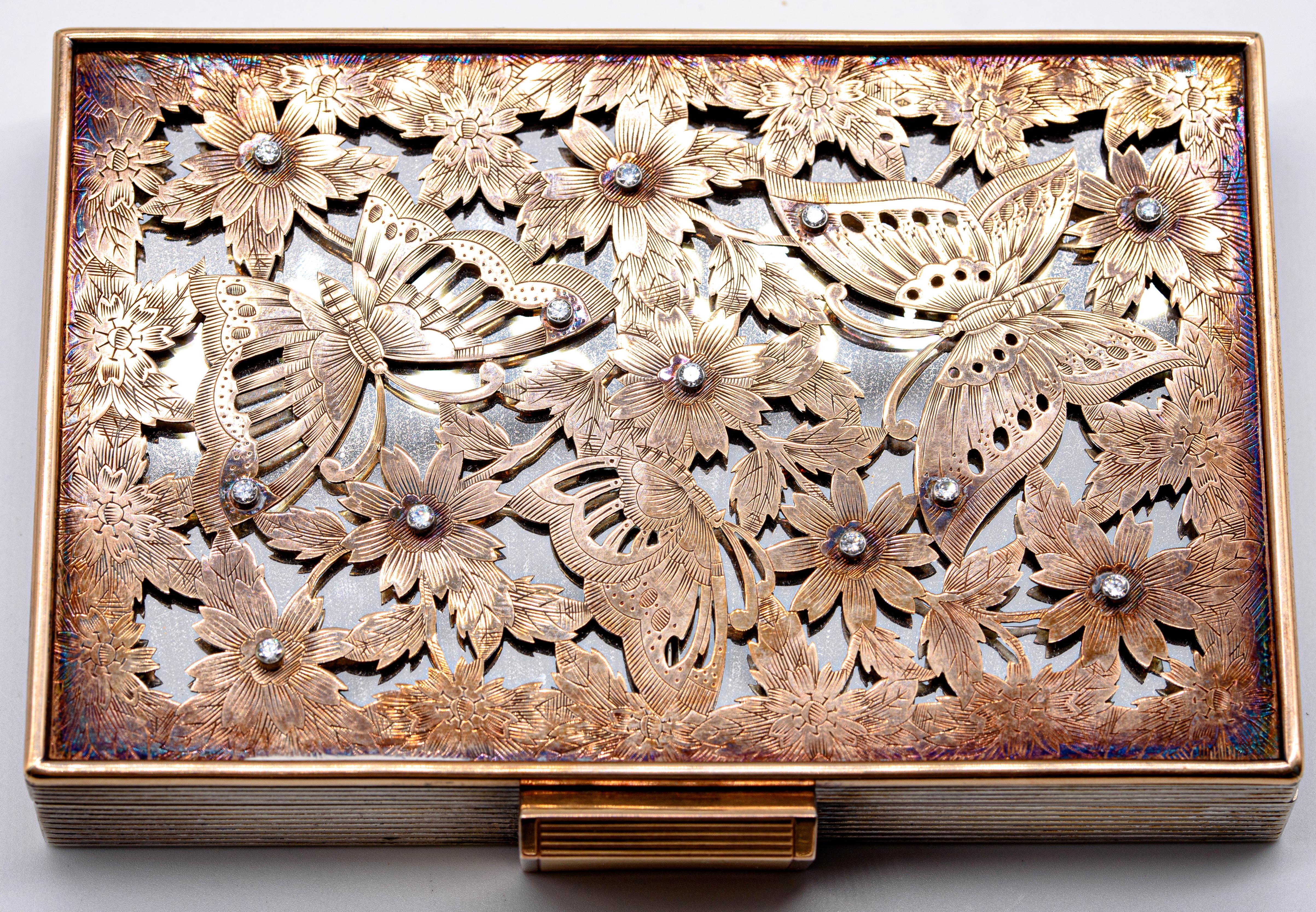  An elegant and amusing little minaudière recalling the elegance and fashion of the 1930's.  Diamond sprinkled butterflies on the cover open at the hinge to reveal numerous compartments: a perfume dispenser, lipstick, a comb receptacle, a square