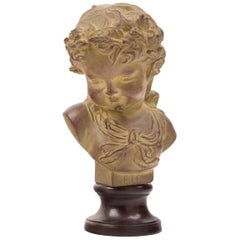 Encantador busto francés de terracota sobre base de madera ebonizada que representa a un niño pequeño.