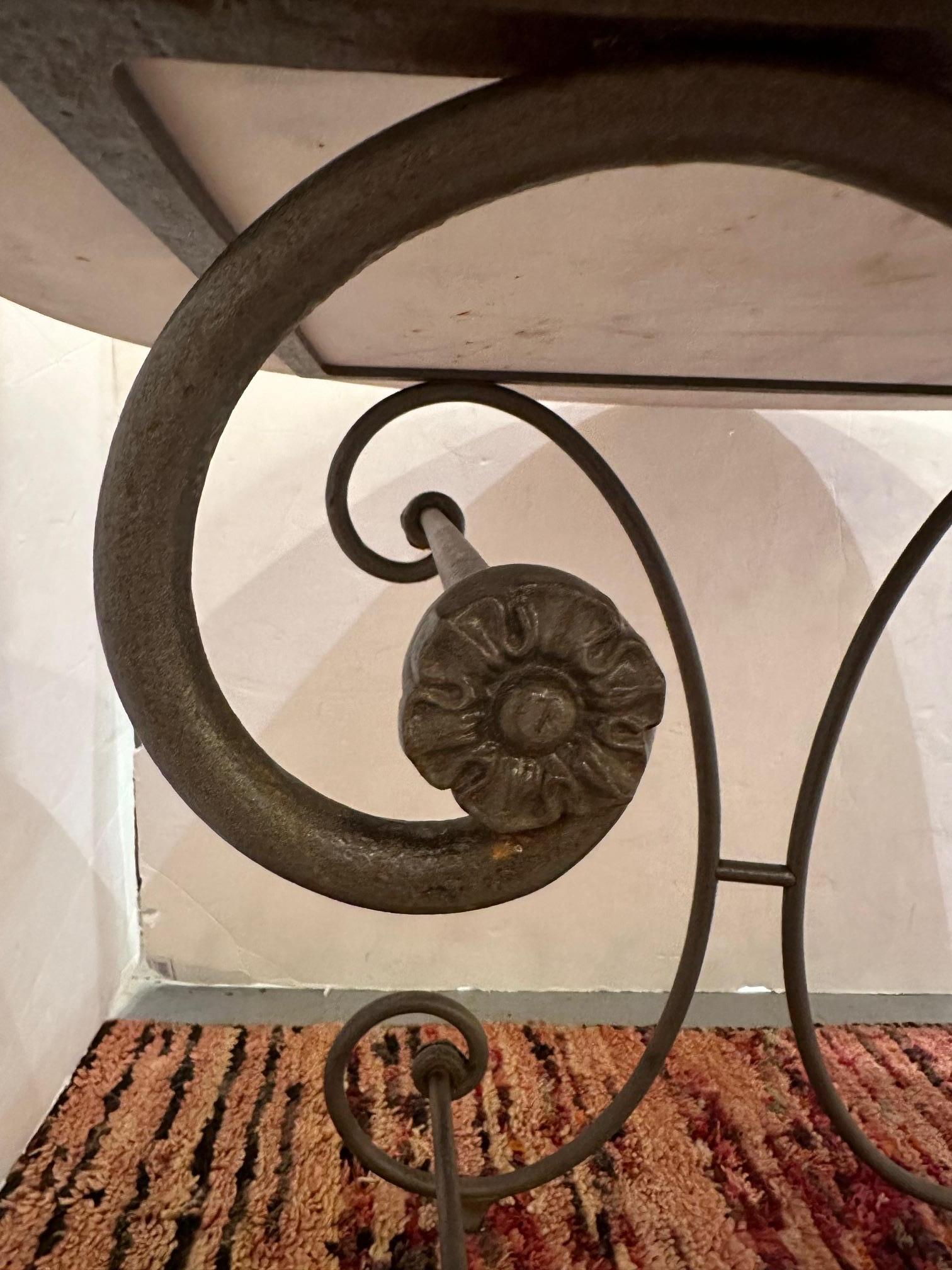 Charming vintage French round dining table having curlicue iron base and original white marble top.  Can be used indoors or on the patio.