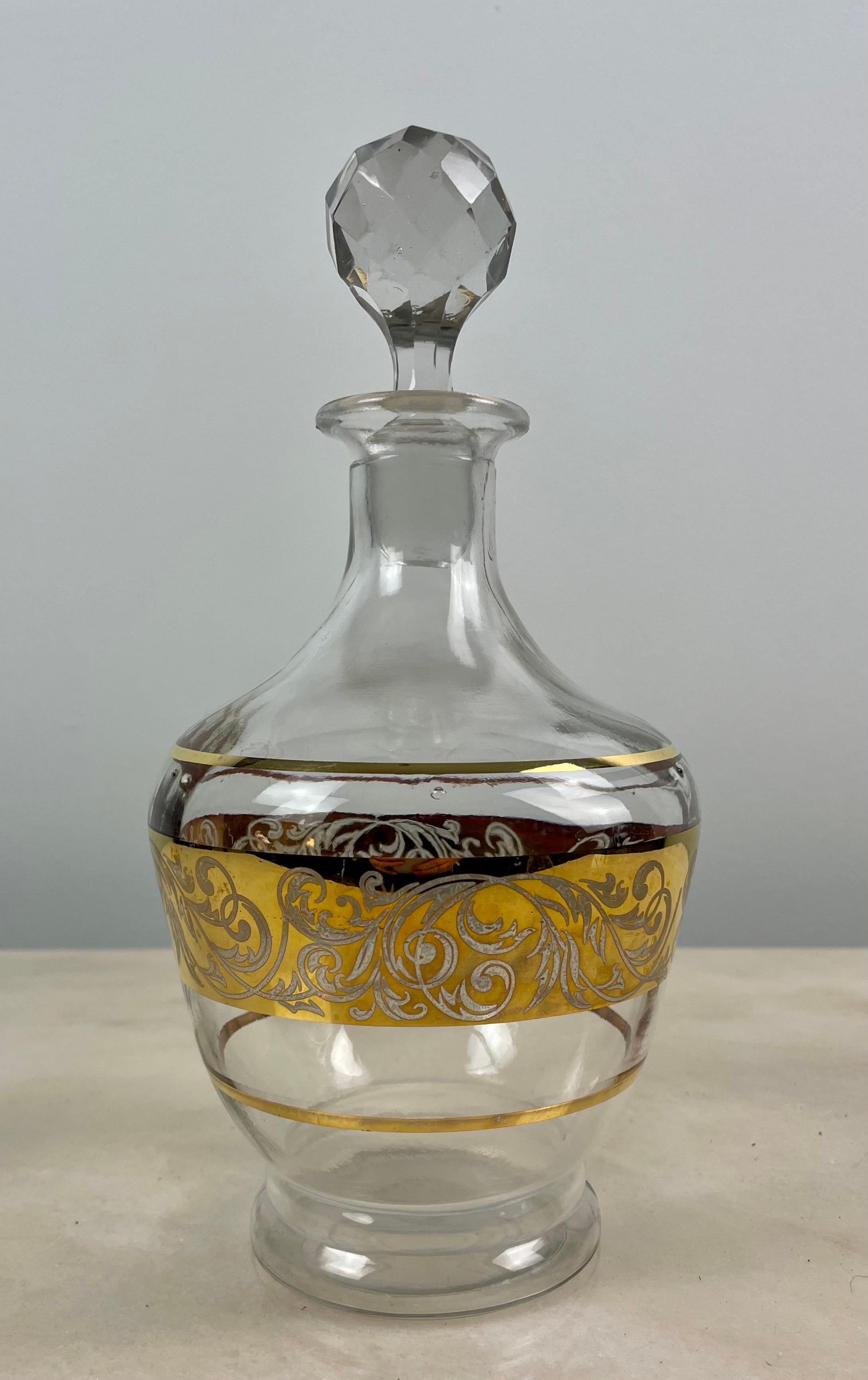 Charming glass decanter with its cut glass stopper.
Carafe decorated with gilded edging and band of gilded foliage.
Circa 1950.