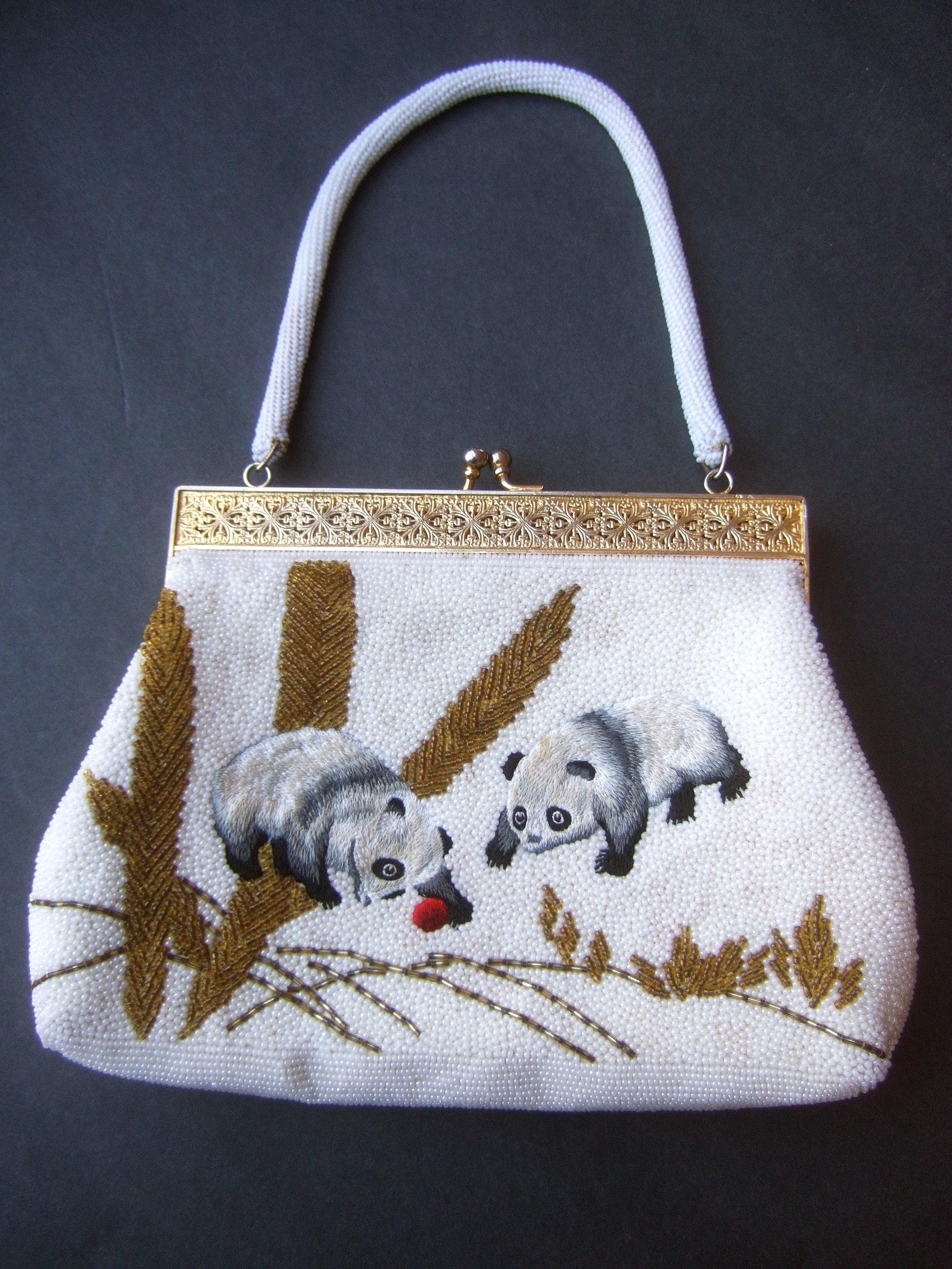Charming glass hand-beaded embroidered panda evening purse c 1960s 
The artisan evening bag is encrusted with intricate rows of tiny white glass beads
that emulate snow

Designed with a pair of endearing hand-embroidered panda bears set against the