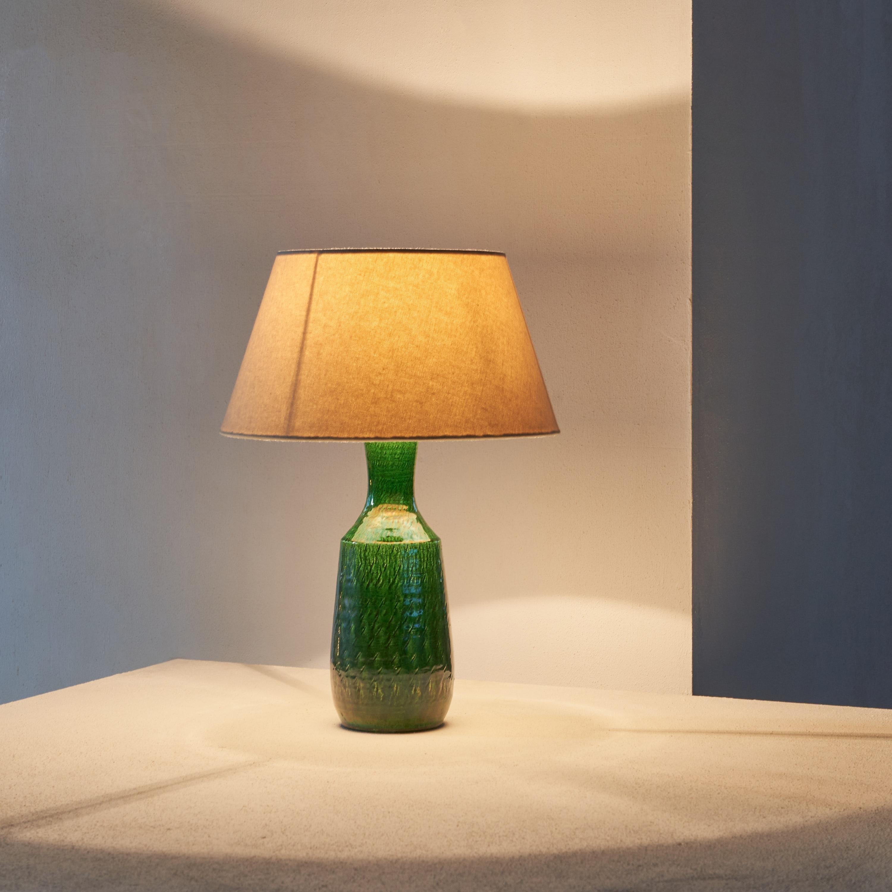 Charming Green Glazed Studio Pottery Table Lamp. Most probably Scandinavian, 1960s.

This 1960s green glazed charming studio pottery table lamp with fabric shade is the perfect addition to any home. Its unique style and design make it a great