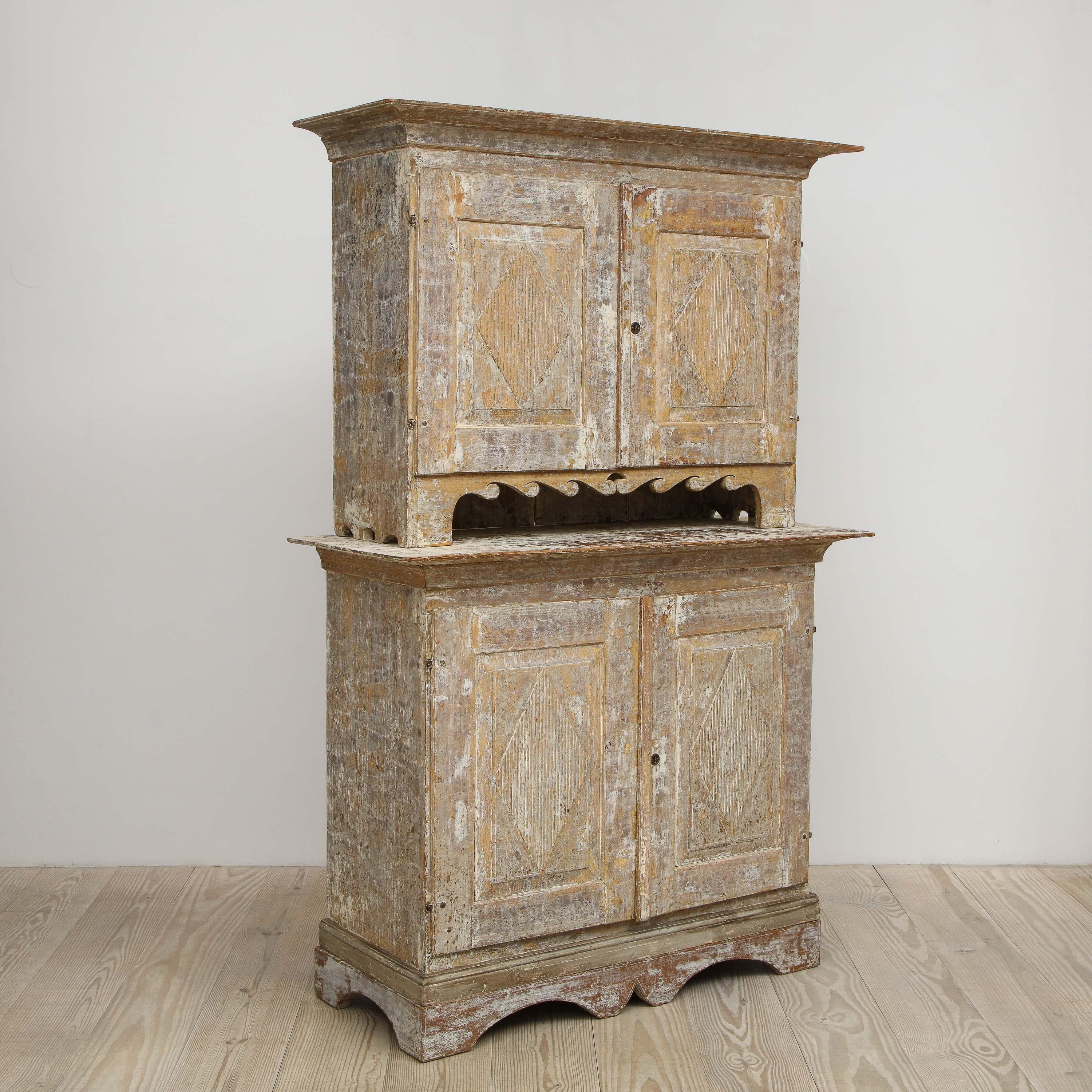 Charming Gustavian cabinet, circa 1790, origin Sweden, upper cabinet with scalloped wave pattern and hand-carved diamond patterns on each door sits atop the lower cabinet. 

The beautifully layered, hand-painted original color and elegant surface