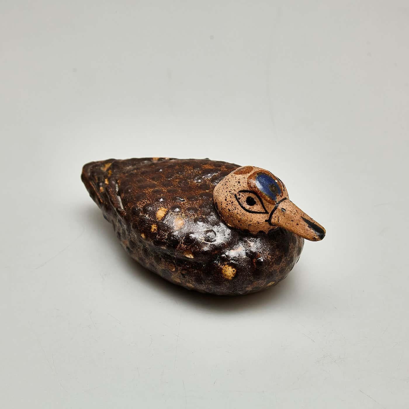 Lassen Sie sich von dem rustikalen Charme dieser traditionellen und primitiven Keramikskulptur verzaubern, die sorgfältig von Hand bemalt wurde, um das Wesen einer Ente einzufangen. Dieses entzückende Stück verkörpert mit seiner Schlichtheit und