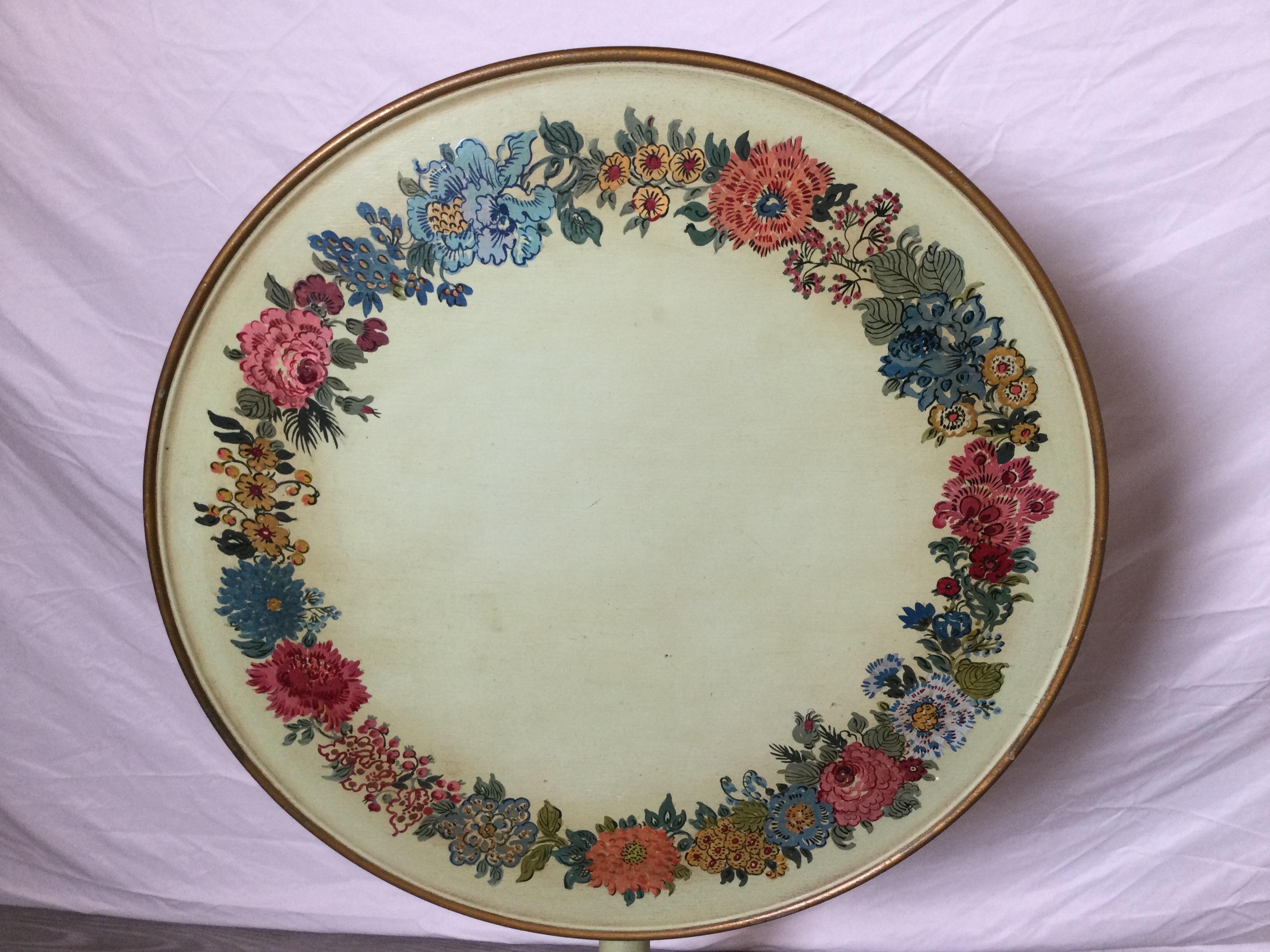 A charming light sage green hand painted tilt top tea table. The solid wood with a base of light sage green with hand painted floral border around the top.