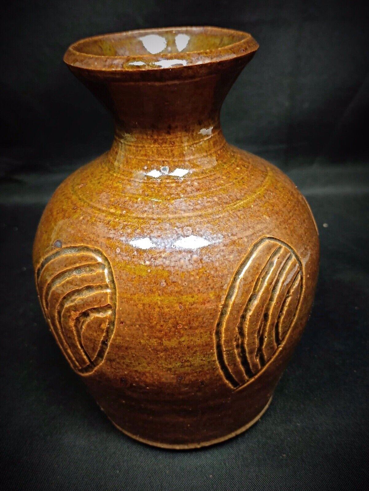 Ce magnifique vase artisanal, signé par P.M.P., est une pièce unique et décorative qui ajoute une touche de charme artisanal à tout espace. Fabriqué en terre cuite et recouvert d'une riche glaçure brune, il témoigne du savoir-faire artisanal qui a