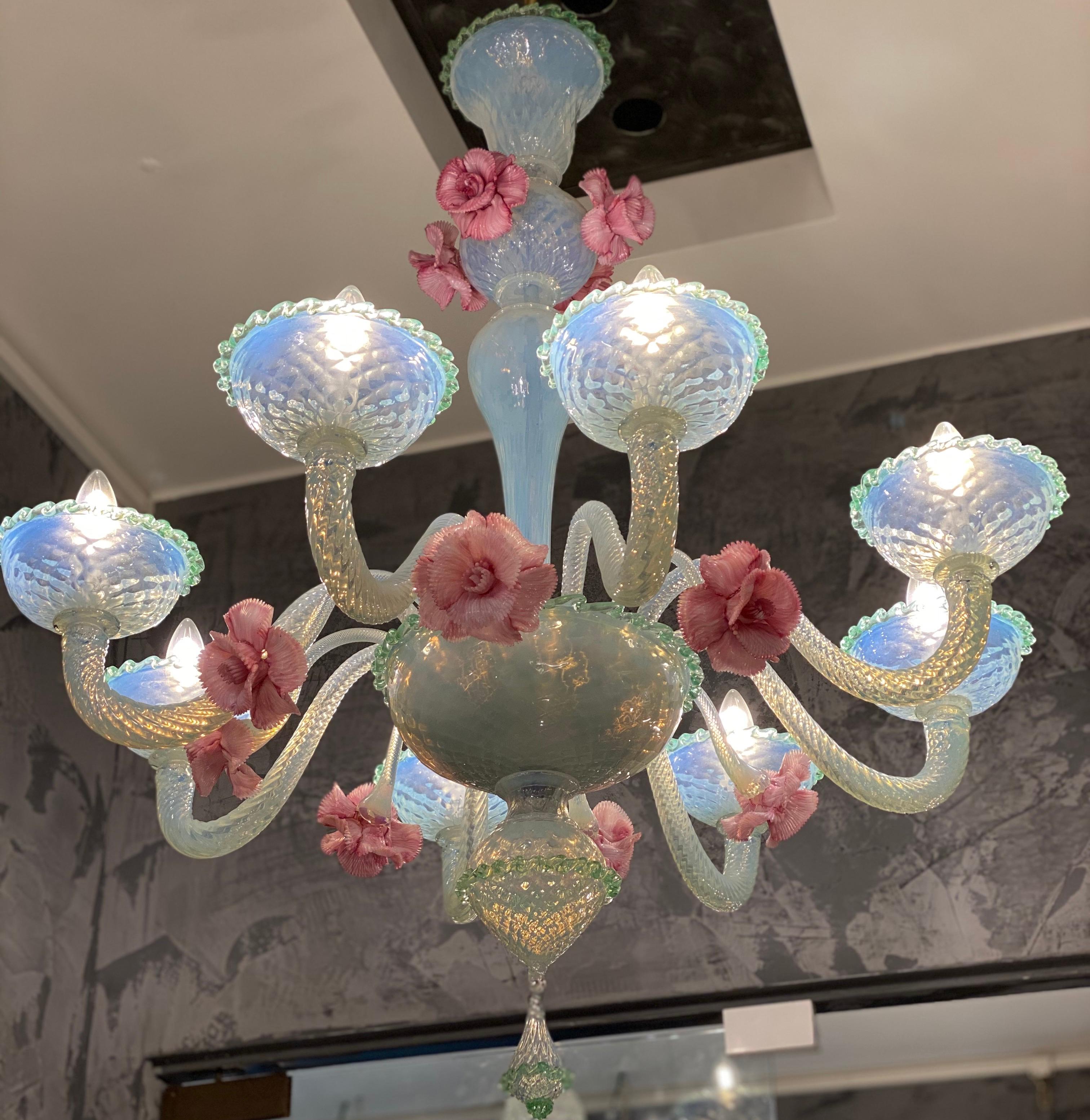 Amazing light opaline blue iridescent Murano glass chandeliers with eight arms decorated with pink pasta vitrea flowers.
Unique piece.