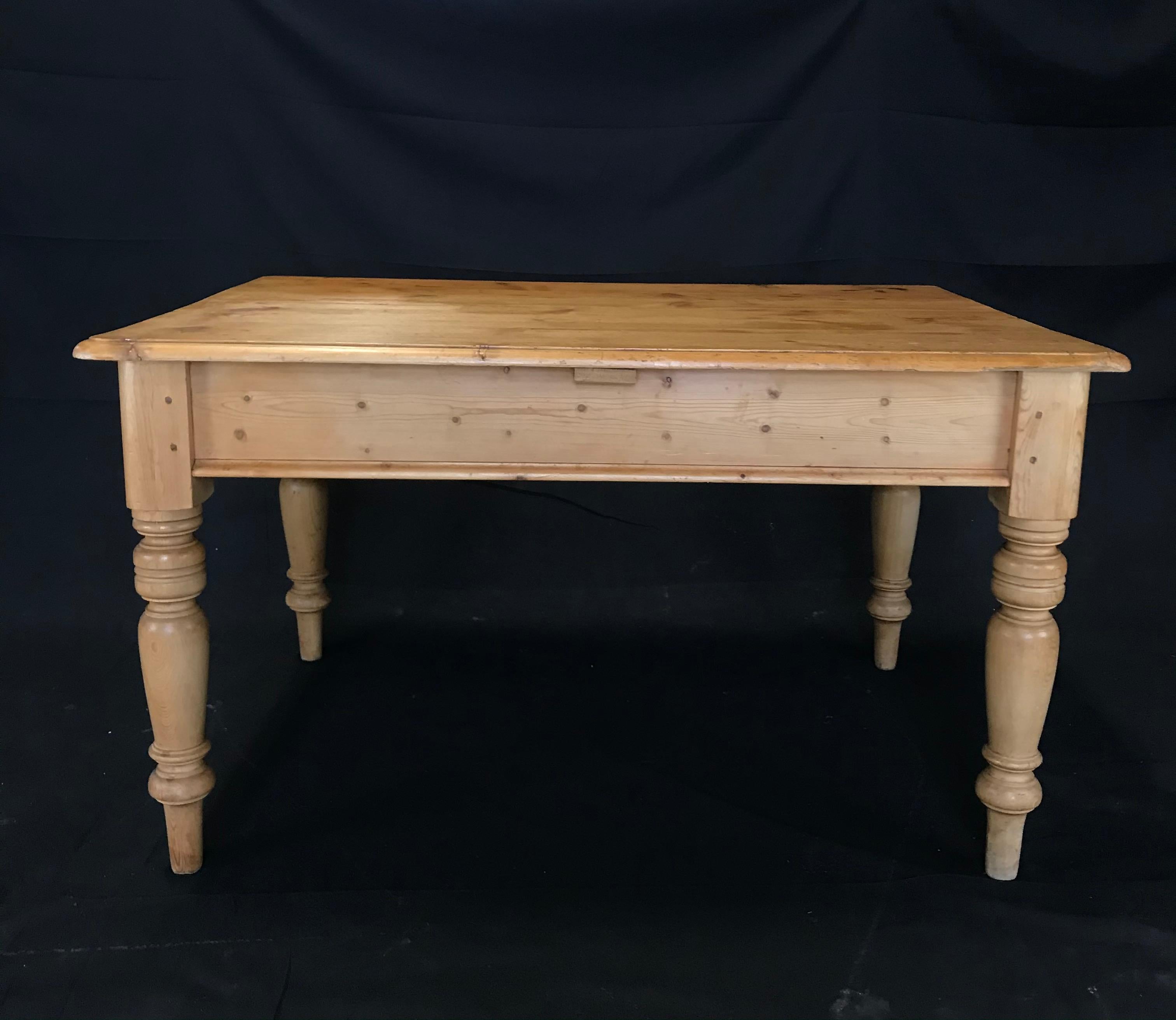 19th century Irish scrubbed pine table, work table or desk having beautiful beveled edge top and turned legs. The top is made up of scrubbed planks and follows down to a simple apron, supported on beautifully turned, slightly tapered legs, ending in