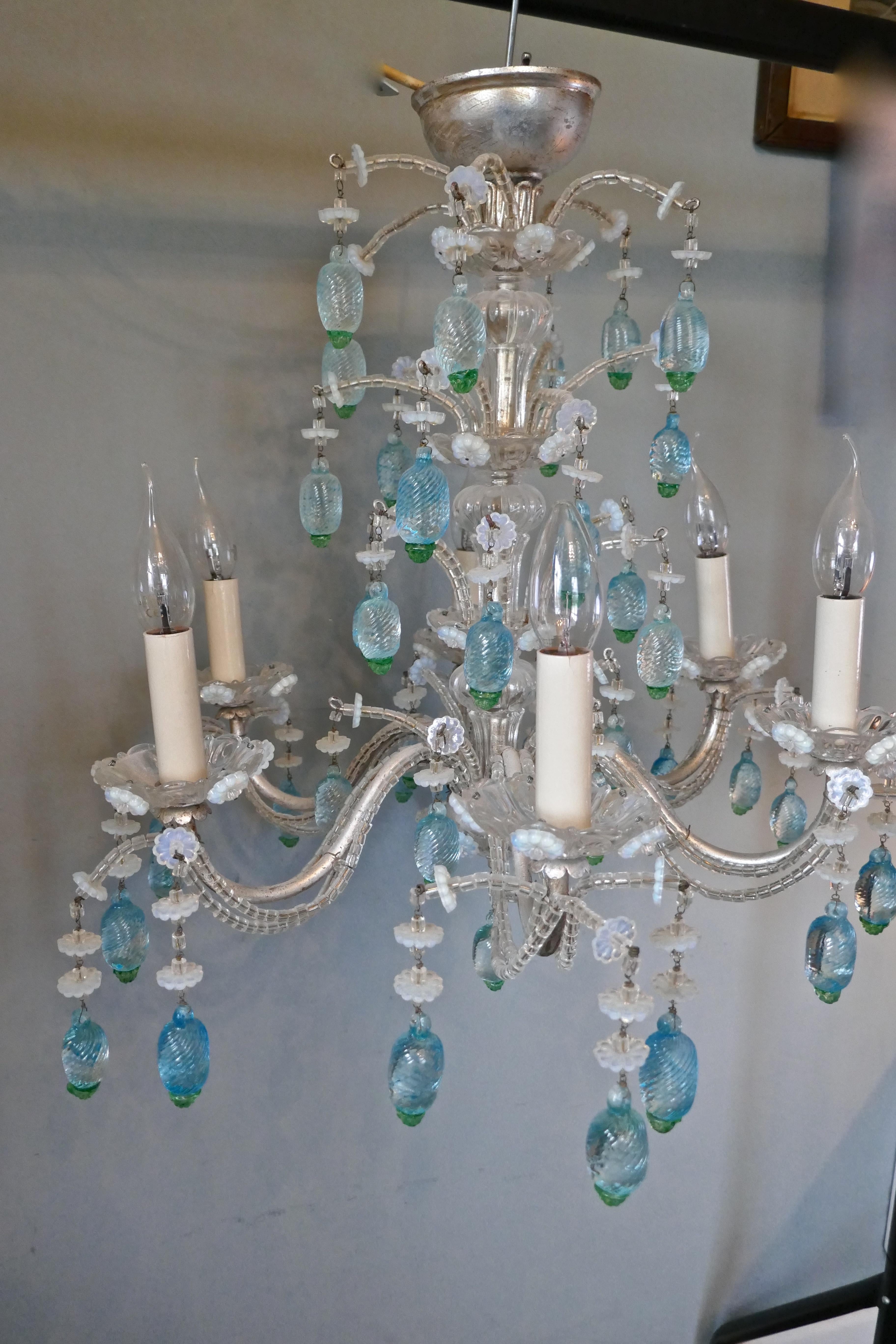 A charming Italian silvered opaline chandelier.

This is a superb Italian chandelier, the elaborate silvered arms are hung with beaded chains, the 6 arms have glass sconces. 
The glass centre column has an unusual waterfall shape, the light is