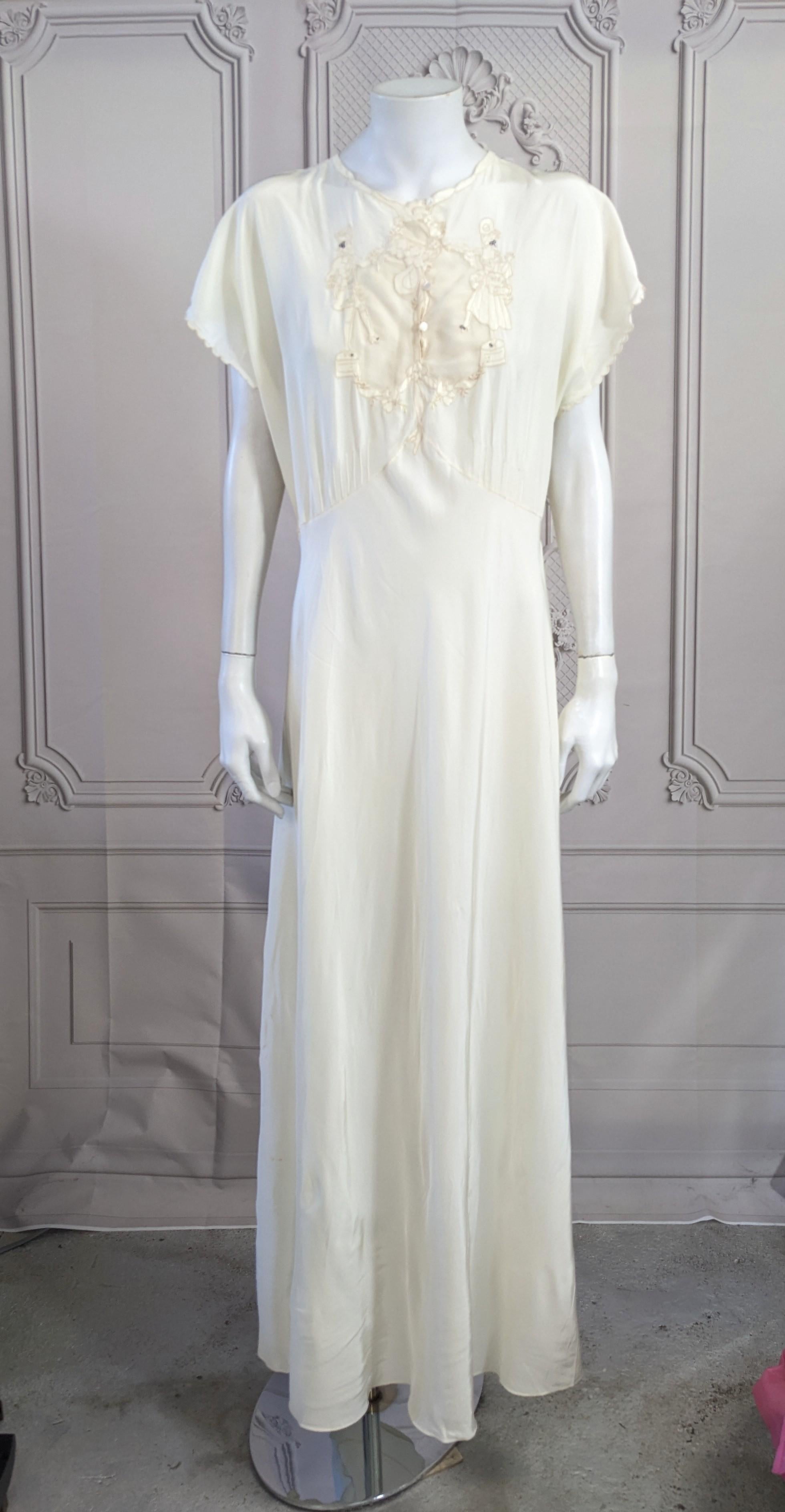 Charmante et inhabituelle robe à bretelles en ivoire avec broderies de courtisane des années 1940. Les courtisanes dansantes du XVIIIe siècle en satin sont brodées à la main sur le corsage, avec une zone transparente sur le buste et de minuscules