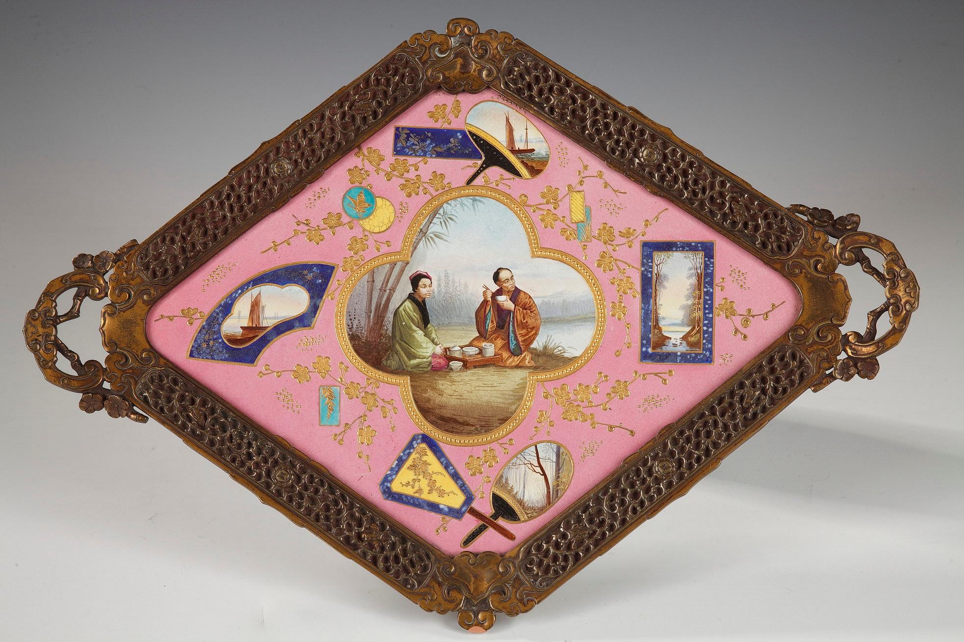 Rare Japanese style diamond-shaped tray attributed to l'Escalier de Cristal, representing lake landscapes in cartouches, and adorned in its center with a lunch scene with a Japanese couple in traditional dress, all highlighted by a gilded decor of