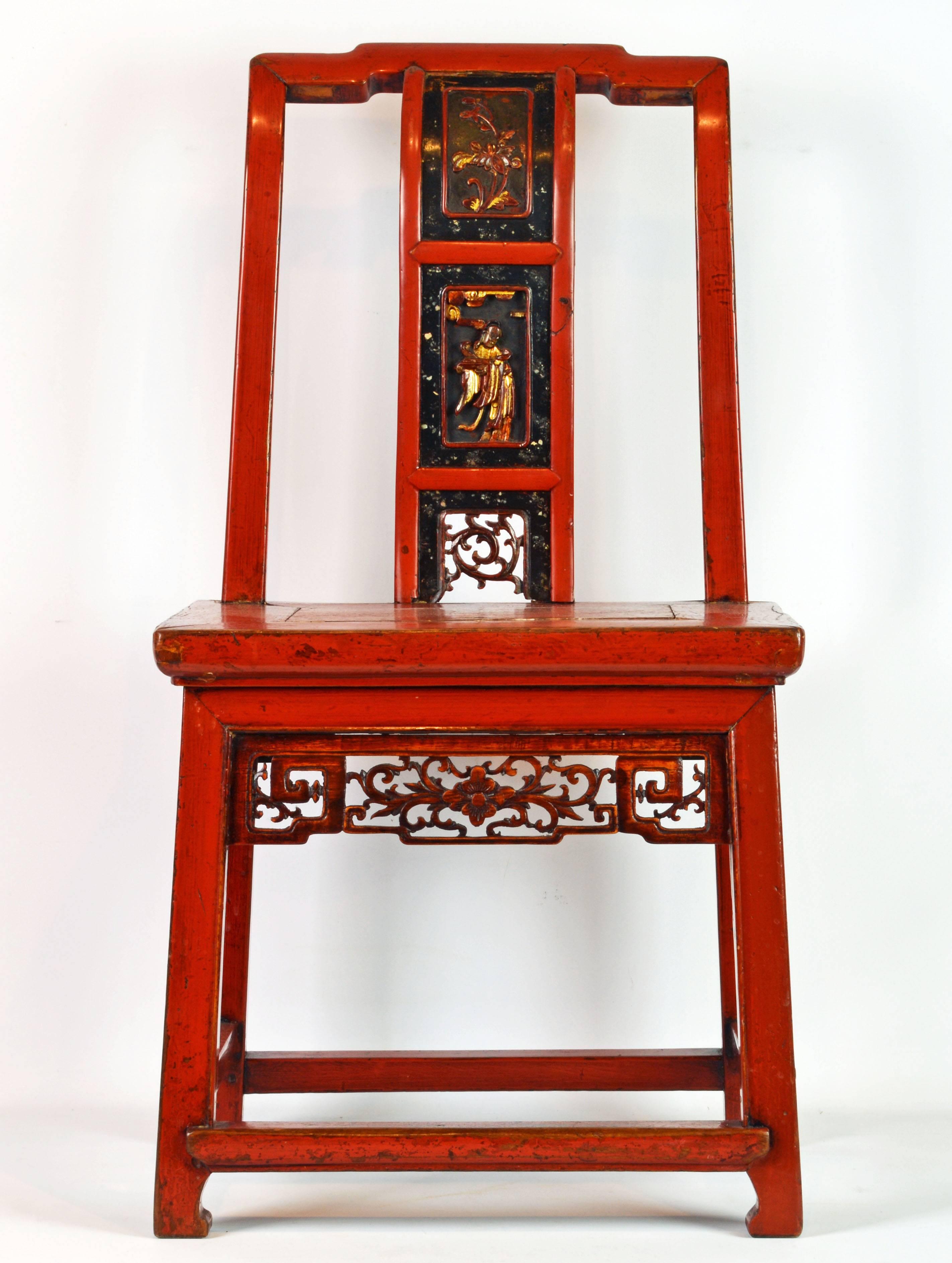 This beautiful small chair features a rich red color with proper patina and wear. The splat of the back is divided into three sections, the upper with a floral design above the main panel carved with a figure and the lower section filled with carved