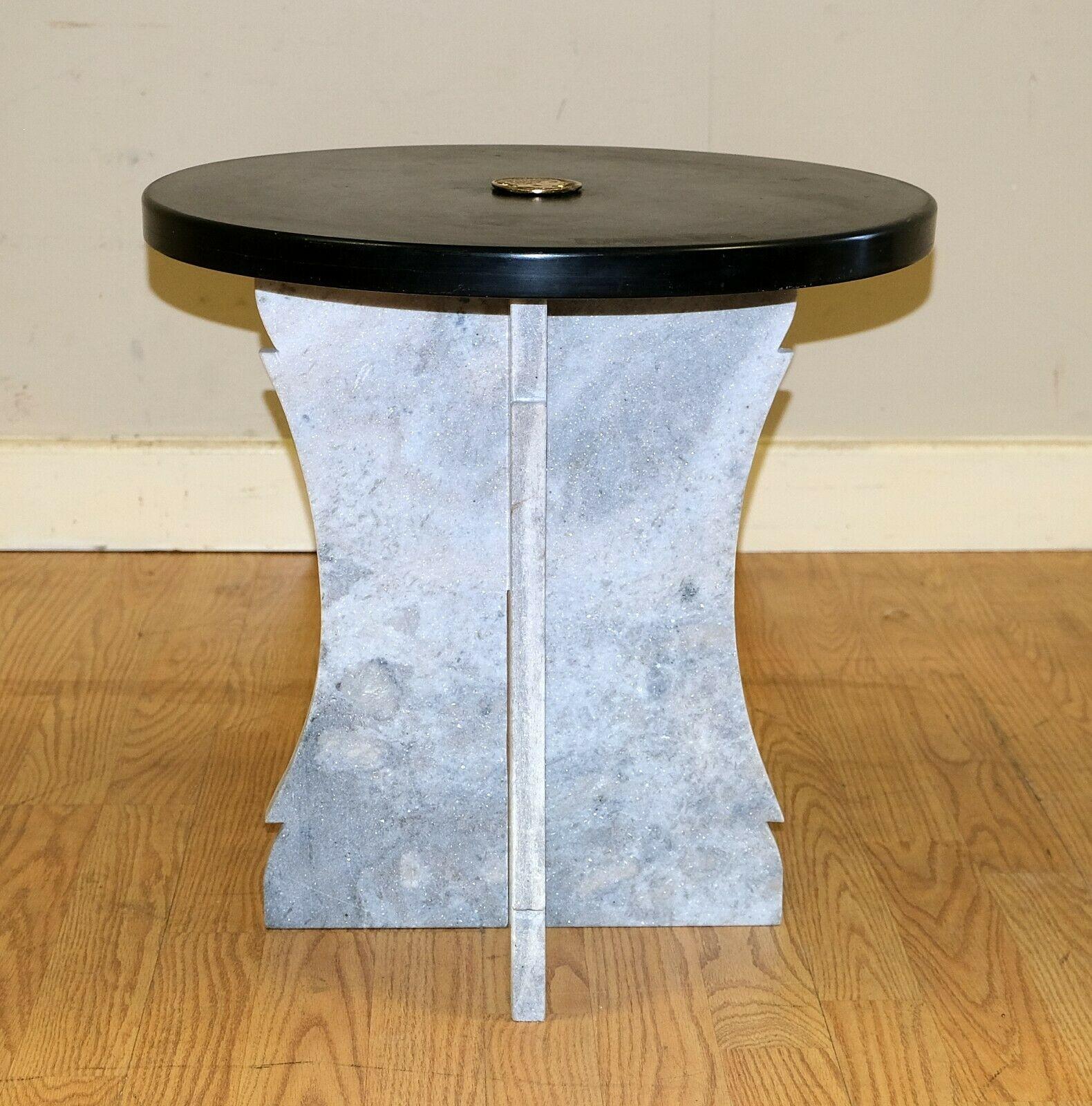 We are delighted to offer for sale this attractive low occasional circular Marble black top table.

This simple but yet good looking table is presented with X base along with a metal Roman head crest in the centre. The table doesn't use much