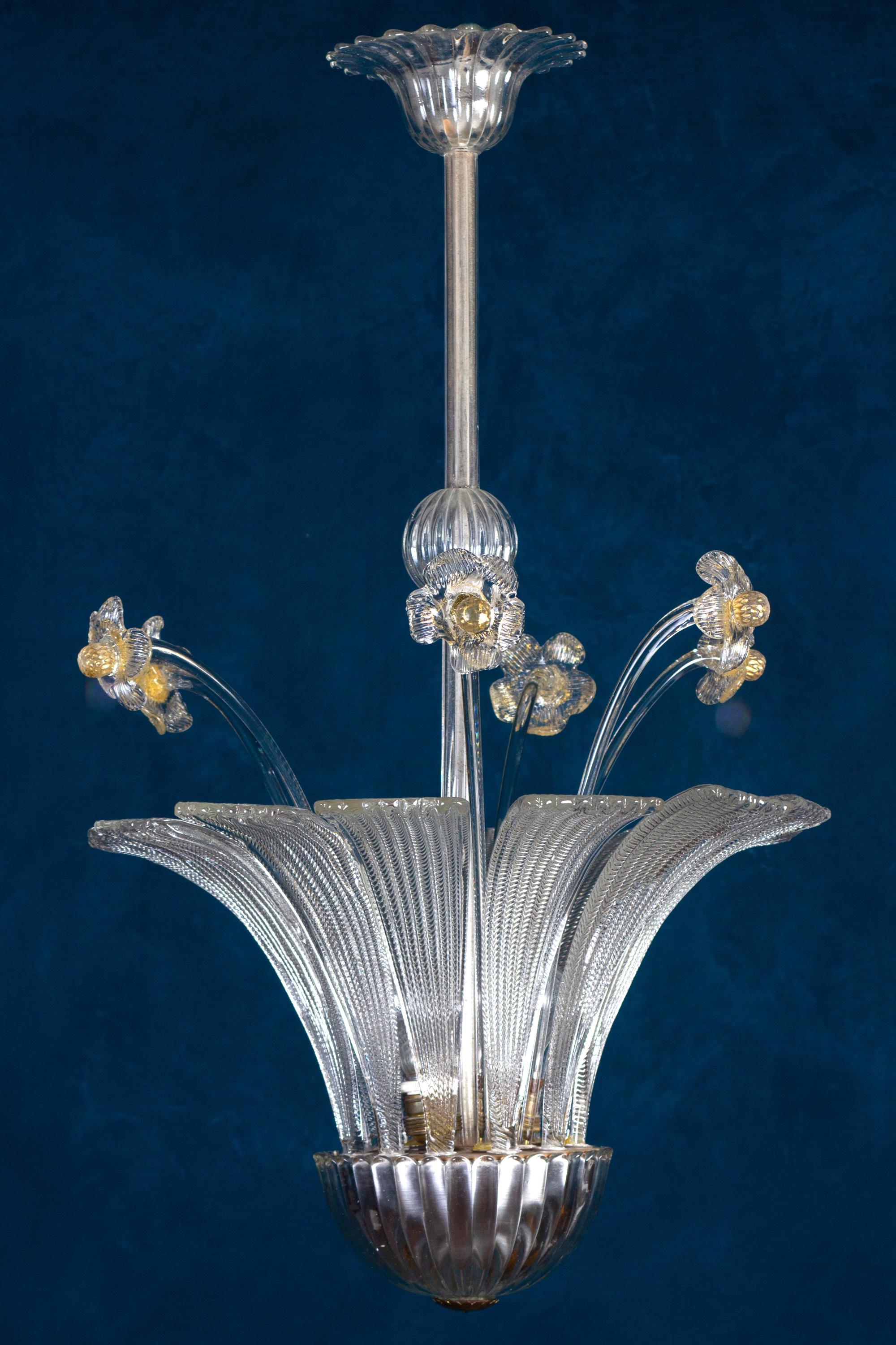 Ce pendentif est centré par une précieuse coupe en verre soufflé à la main de Murano avec des feuilles et des fleurs 
Montée en laiton avec patine naturelle chaude d'origine. 3 douilles E27.
Très bon état vintage.
 