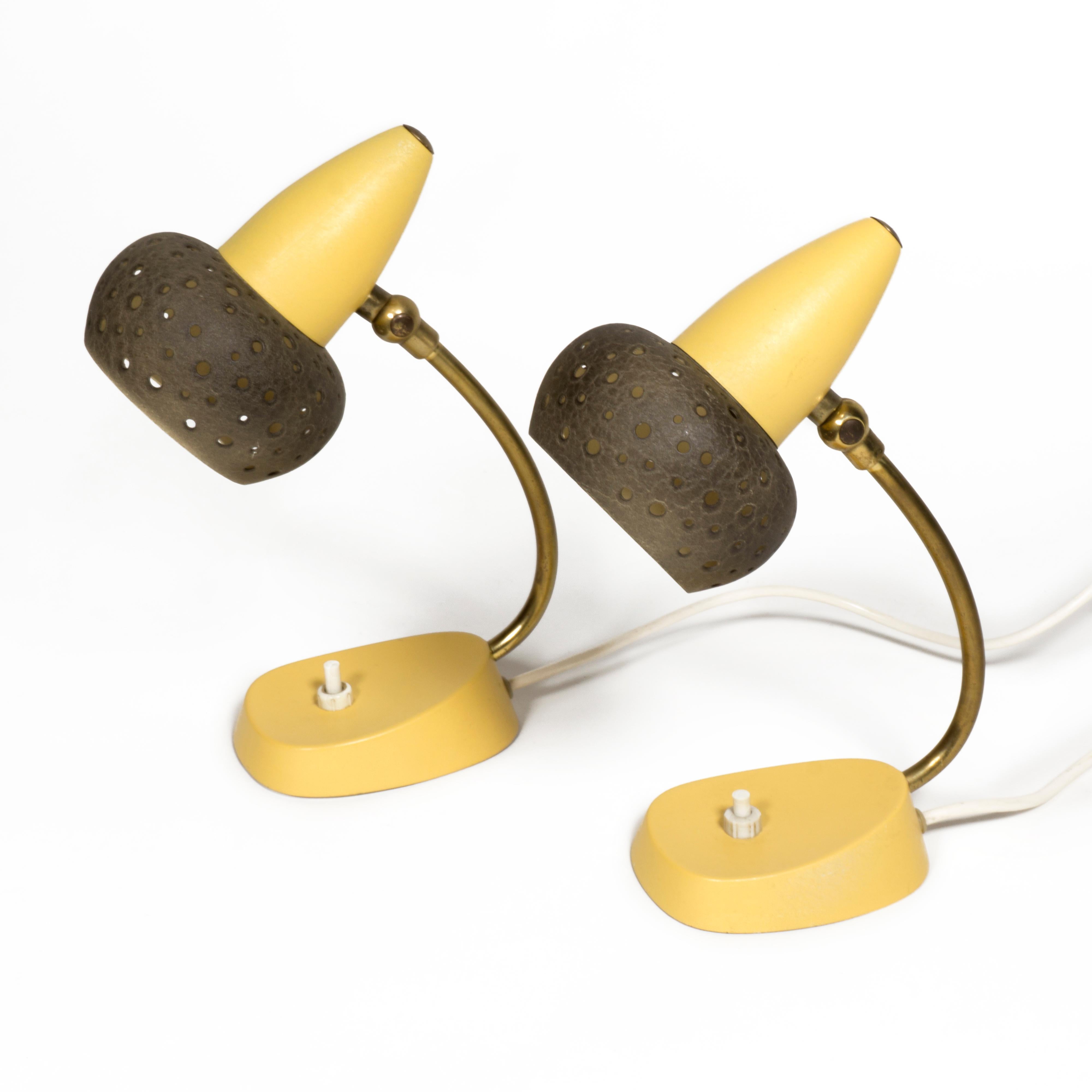 Lovely Set of two Mid Century bedside lamps / table lights from the 1950s.
The perforated shades are finished with yellow and dark brown shrink lacquer, as is the base. The flexible joint allows the shade to be flexibly orientated. One E14 socket