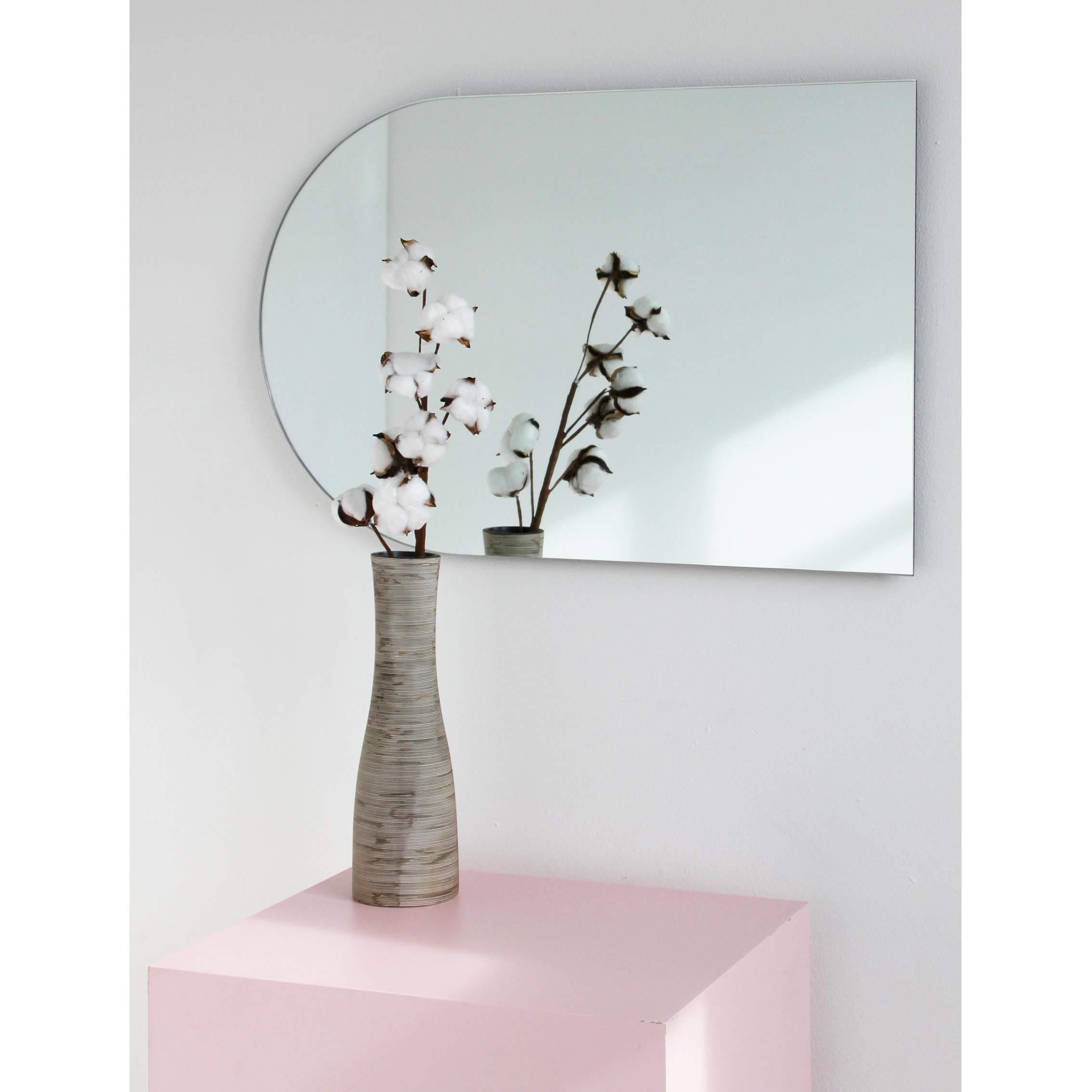 Minimalistischer, bogenförmiger, rahmenloser Spiegel, der in 4 verschiedenen Positionen aufgehängt werden kann. Hochwertiges Design, das dafür sorgt, dass der Spiegel perfekt parallel zur Wand steht. Entworfen und hergestellt in London,