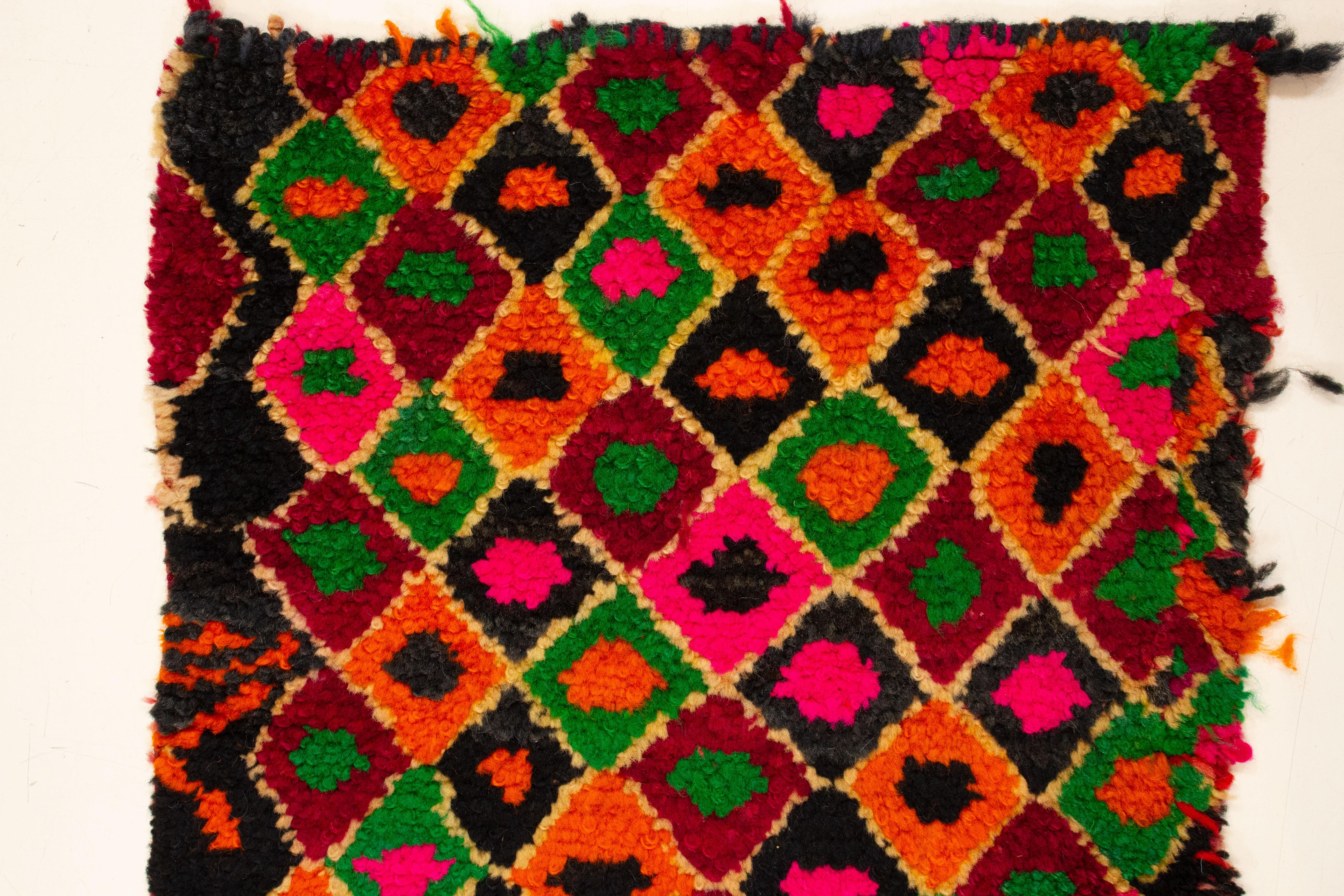 A very charming miniature Berber rug, obtained by unfastening the front panel of a piled pillow case. This was hand-crafted by the highly inventive weavers of the Ait Bou Ichaouen tribe, located in Talsint province very close to the border with