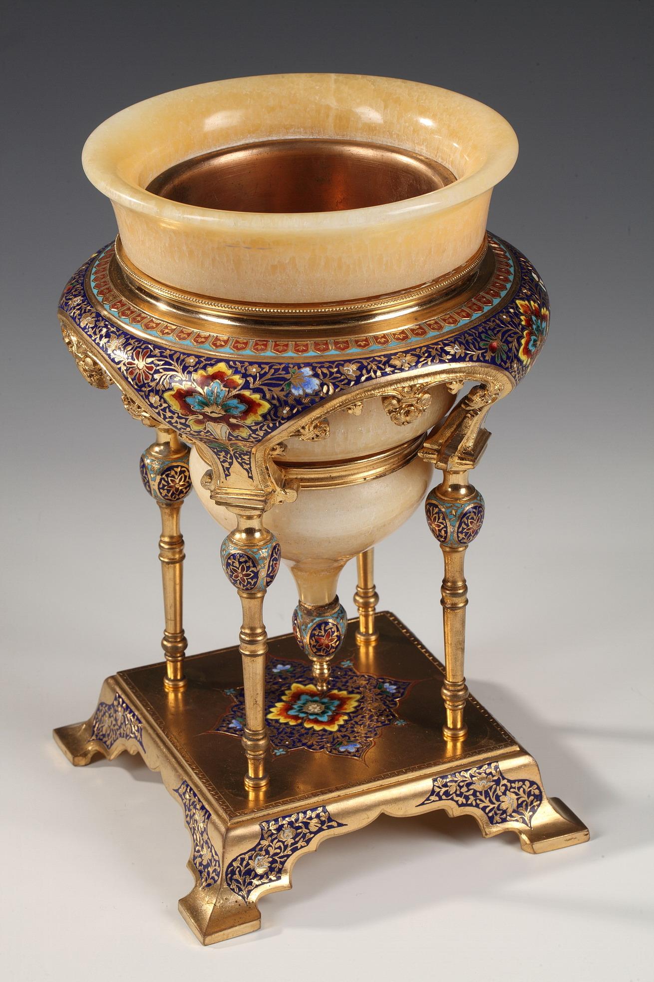 An oriental onyx bowl, attributed to Louchet Frères, inserted in an architectural gilt bronze mounting on four columns supporting a large moulding enriched with polychrome cloisonné enamel foliated patterns. The whole raises on an enameled gilt