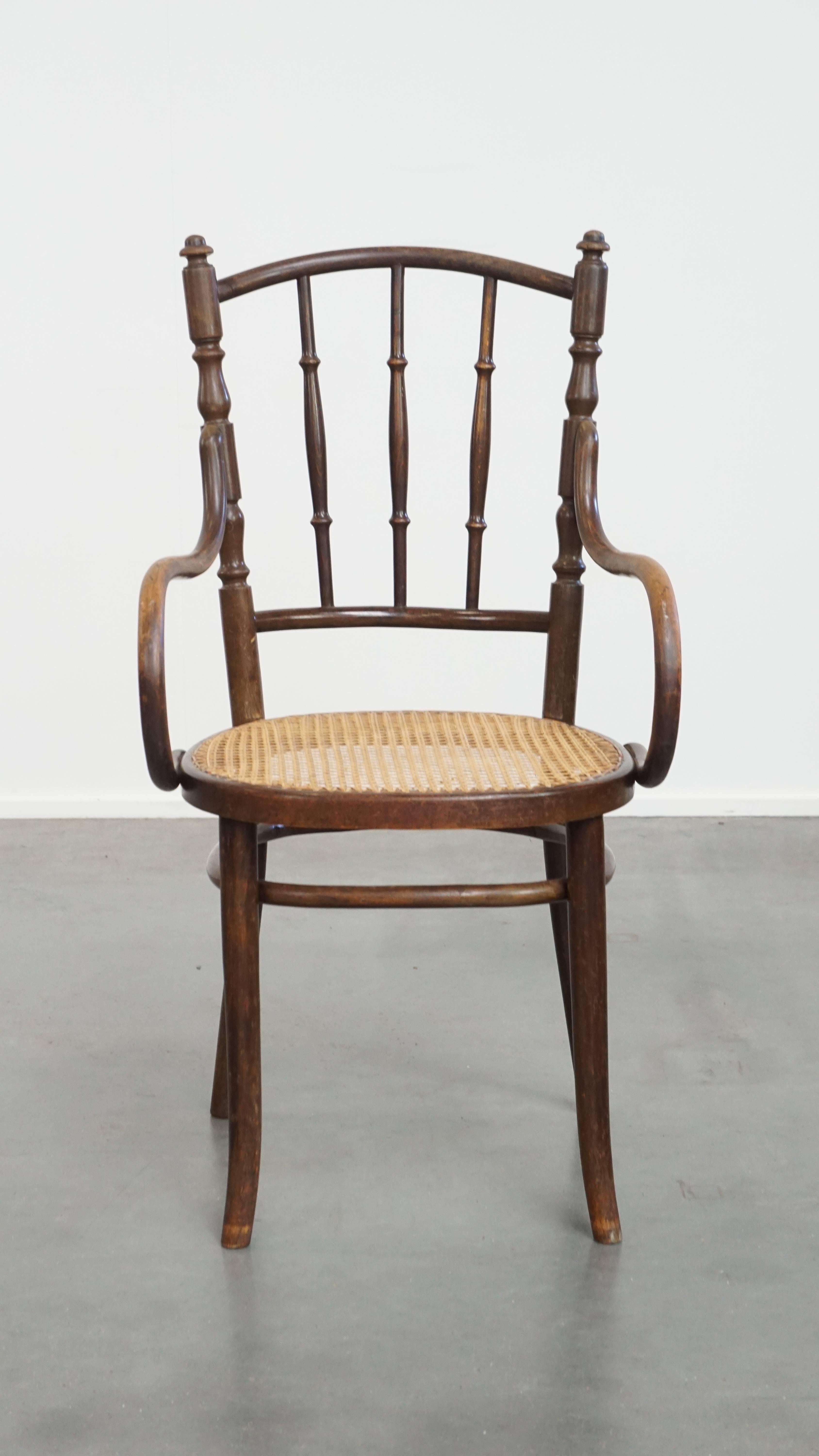 In offerta c'è questa affascinante sedia da bistrot originale d'epoca di Thonet con braccioli.

Questa incantevole sedia è realizzata con una struttura in legno curvato e presenta una seduta in canna intrecciata. Si adatta facilmente a qualsiasi