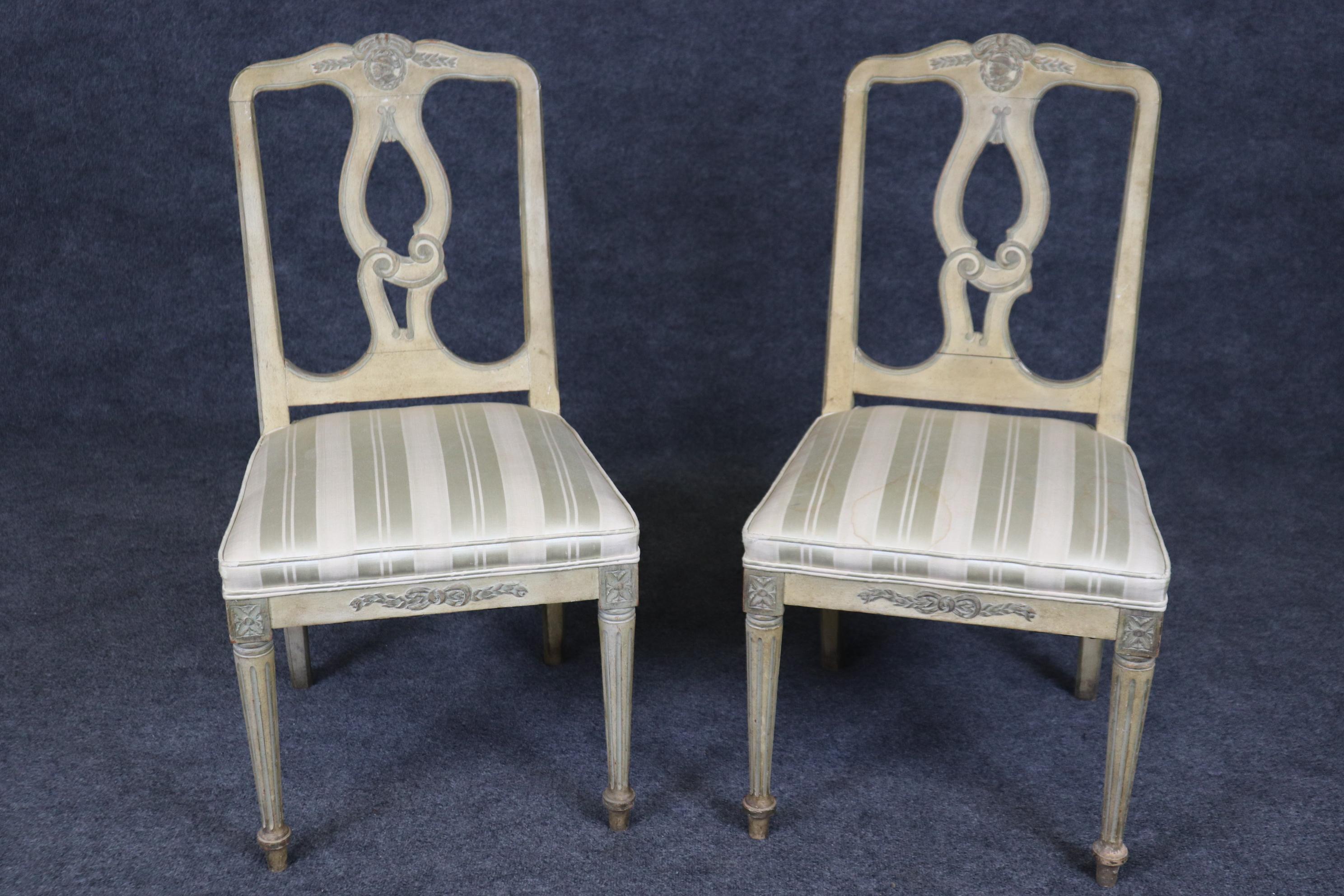 This is a charming pair of paint decorated French Louis XVI style boudoir chairs. Theyt can be used for a foyer next to a center table or in a living room. They are in good antique condition with minimal signs of age and use. They date to the 1940s